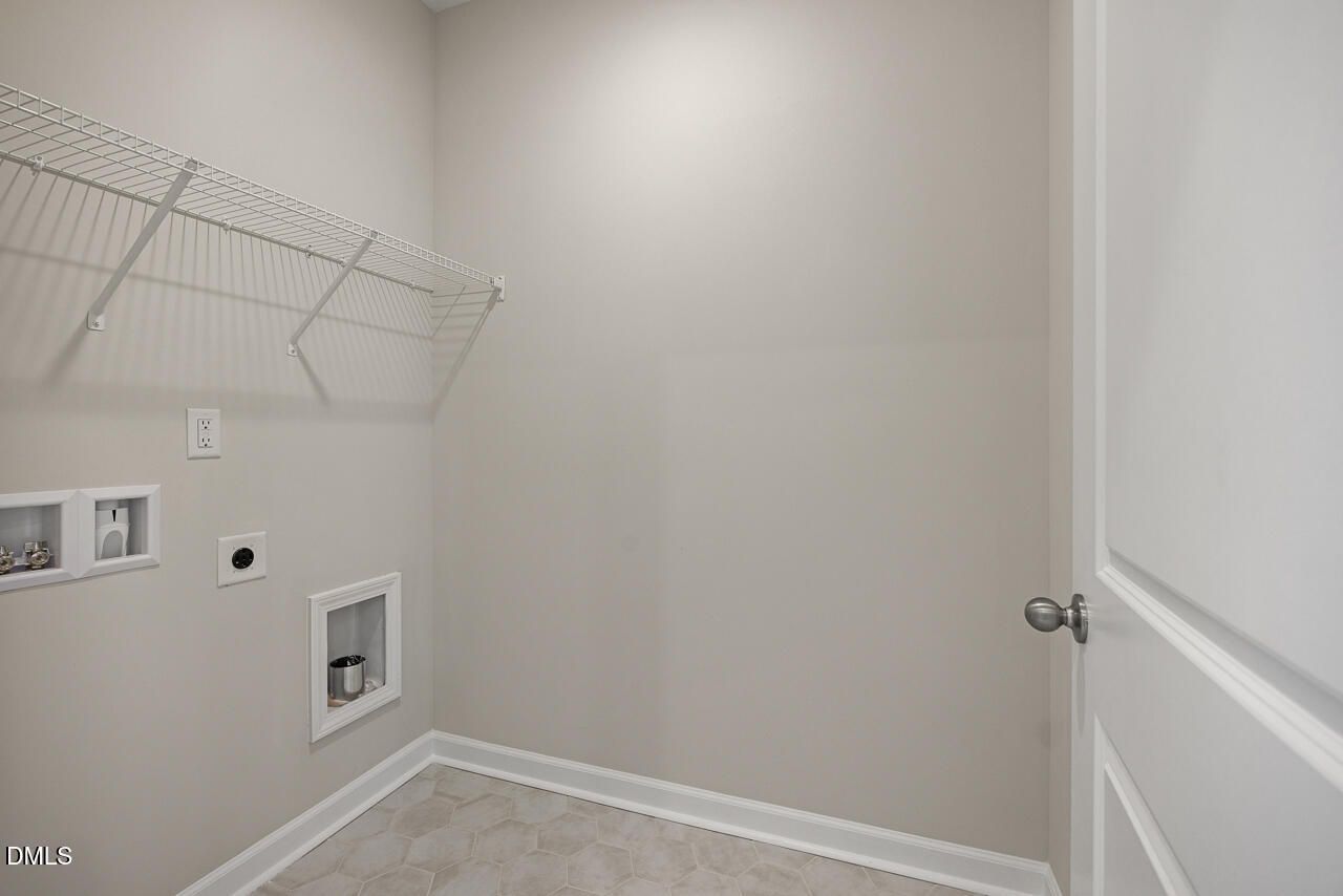 Laundry room with wire shelving and utility hookups in The Alexander C floor plan at Forestville Yard, Knightdale, NC.