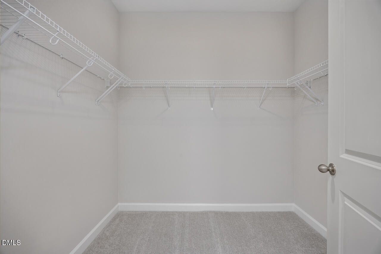 Walk-in closet with white wire shelving in The Ashport L floor plan at Sage on North Main in Wake Forest, NC.