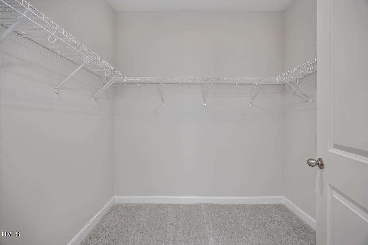 Walk-in closet with white wire shelving in The Ashport L floor plan at Sage on North Main in Wake Forest, NC.