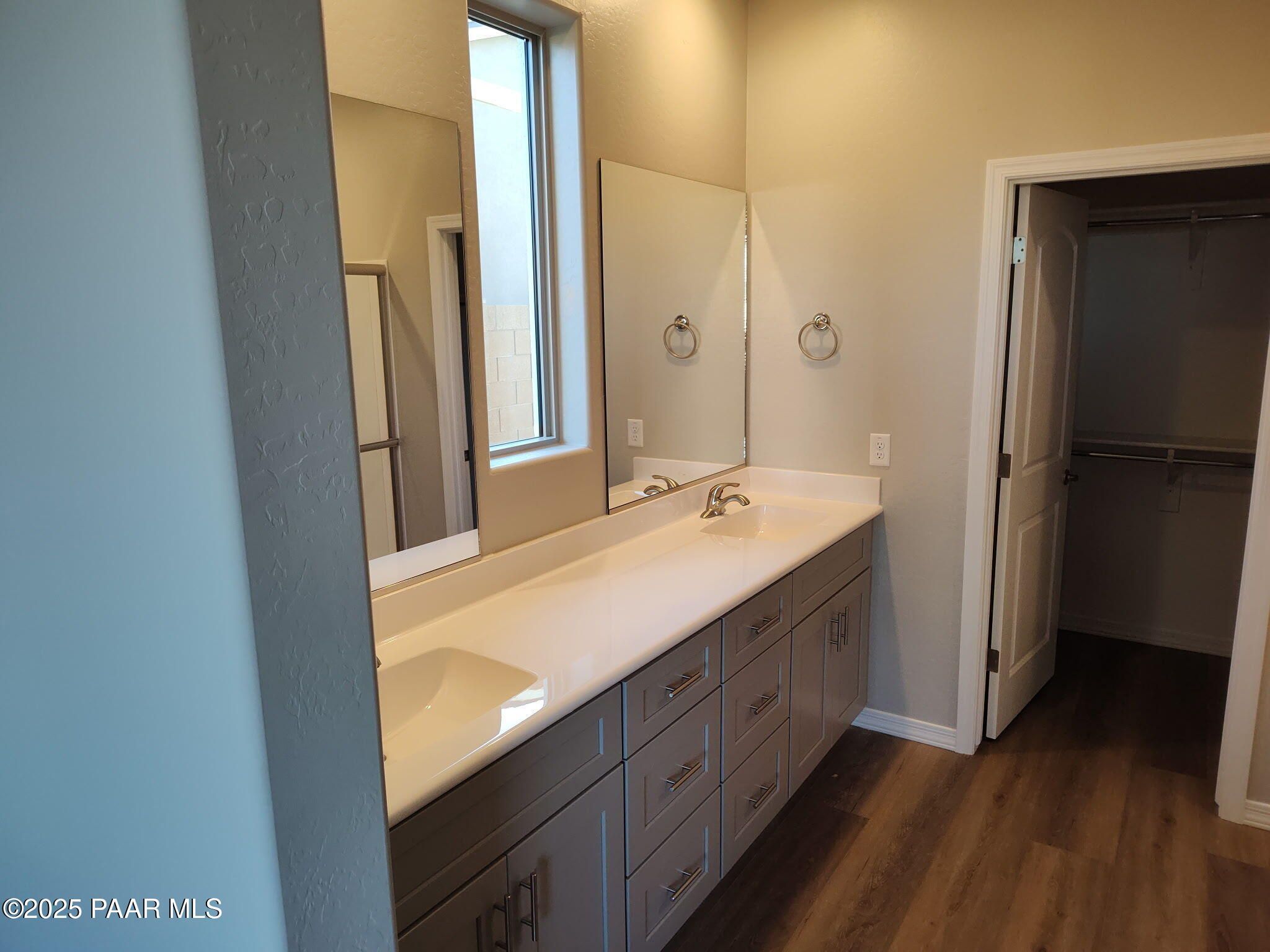 Modern master bathroom featuring double vanity, frameless shower, and walk-in closet in Davidson Homes The Frontier A, Prescott Valley, AZ