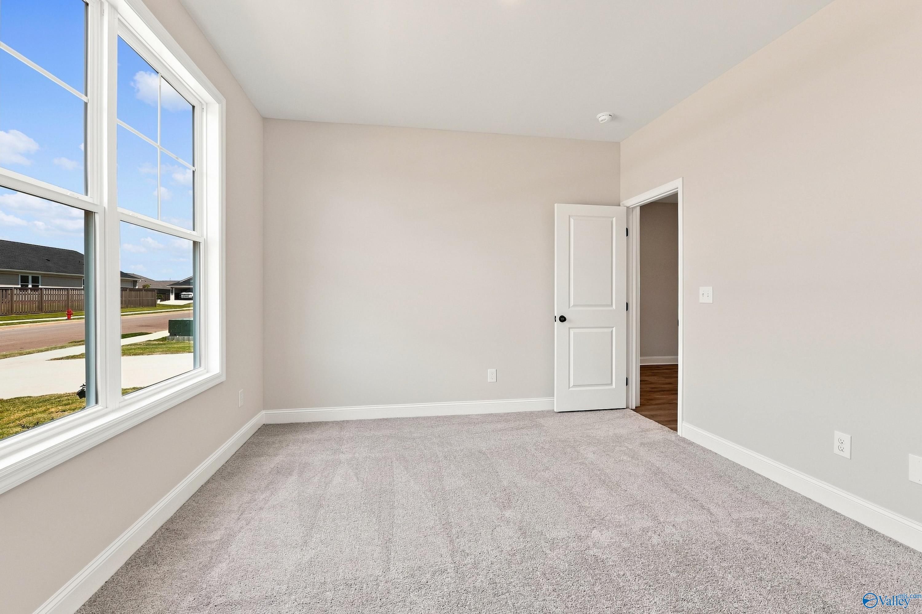 Bright bedroom with plush carpet and large windows in Davidson Homes' The Montgomery D, Anderson Farm, Athens, Alabama