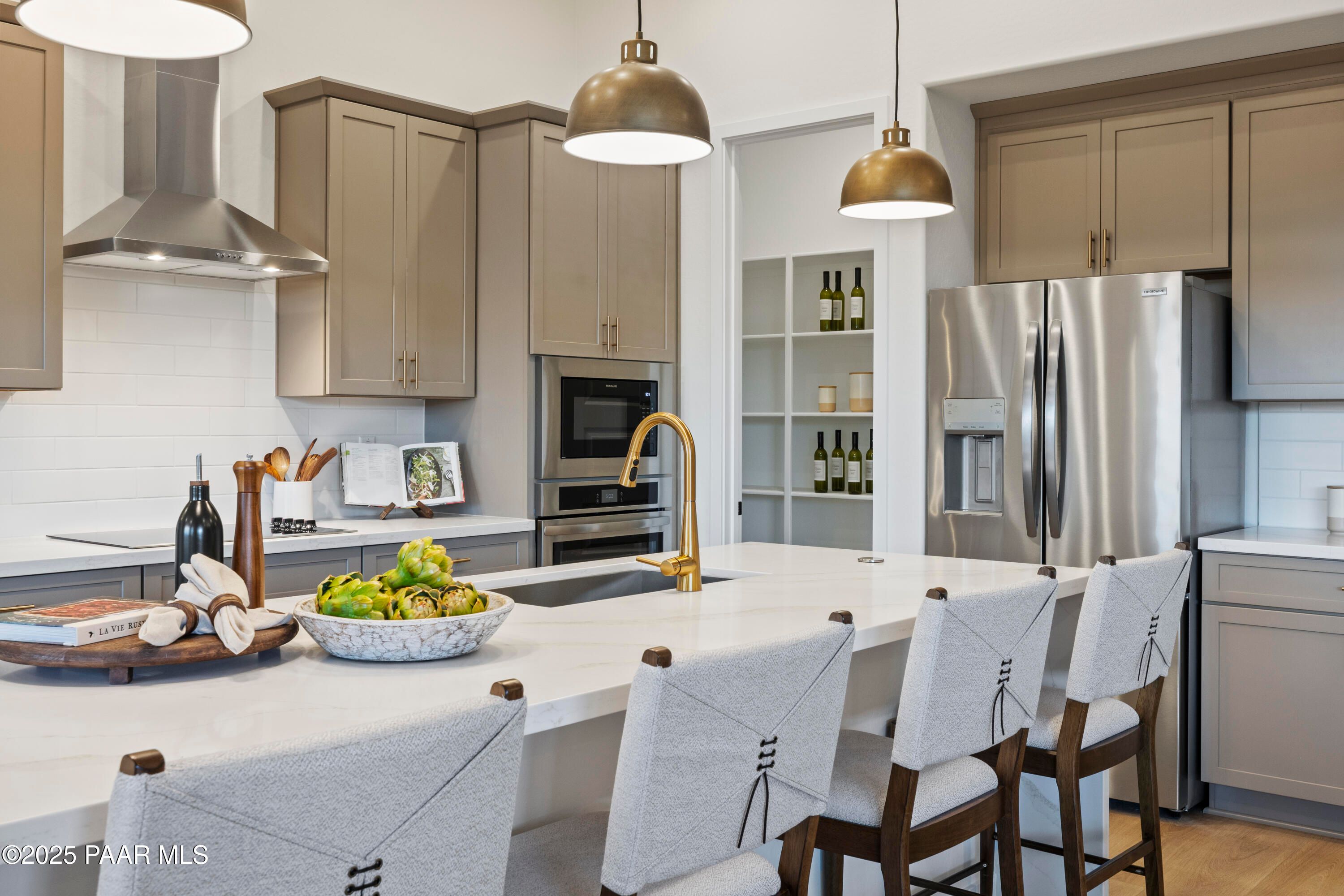 Modern kitchen with white quartz island, stainless steel appliances, beige cabinets in Davidson Homes The Blaze D, Prescott, AZ