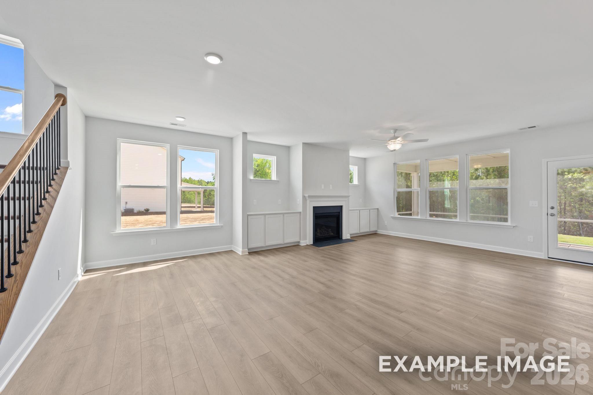 Spacious open-concept living room with fireplace and modern flooring in The Magnolia B home in Windgate, Mooresville, NC.
