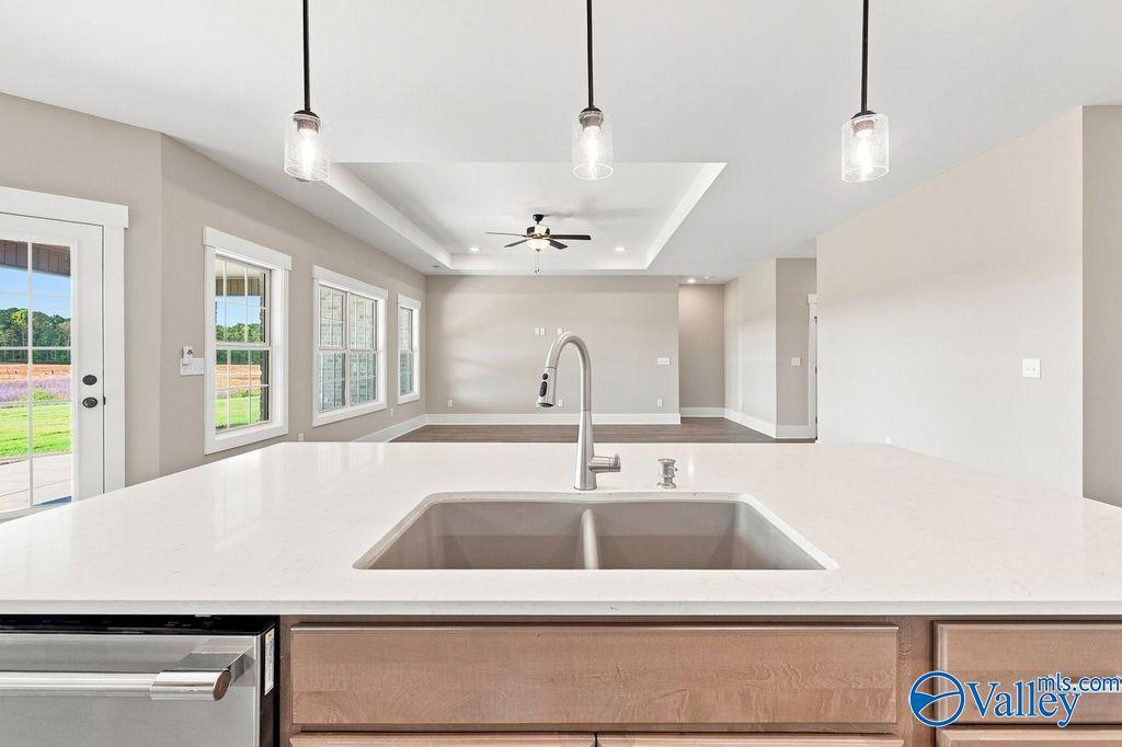 Modern kitchen island with quartz countertops and pendant lighting in The Rockford floor plan, Cain Park, Hartselle, Alabama.
