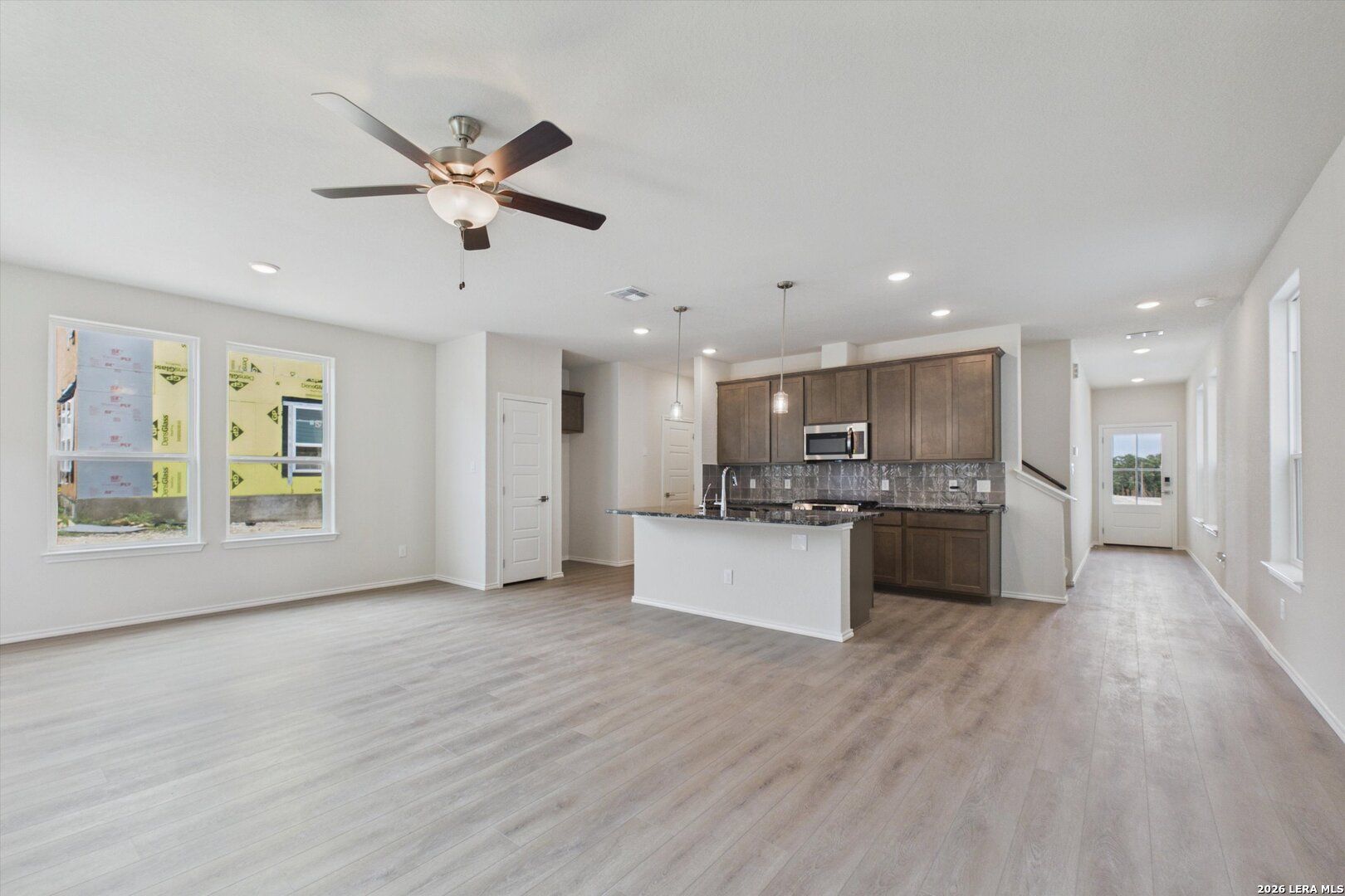 Open-concept living room and kitchen in The Charlotte B floor plan at Meadows at Oak Creek, San Antonio, Texas.