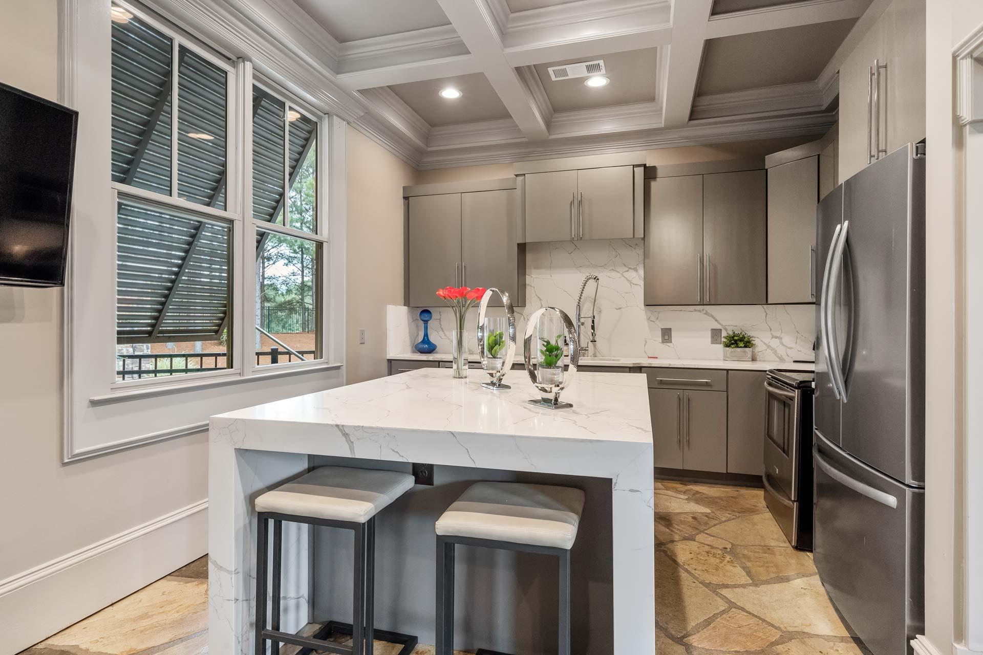 Modern kitchen at The Village at Towne Lake Woodstock GA featuring white quartz island gray cabinets stainless appliances