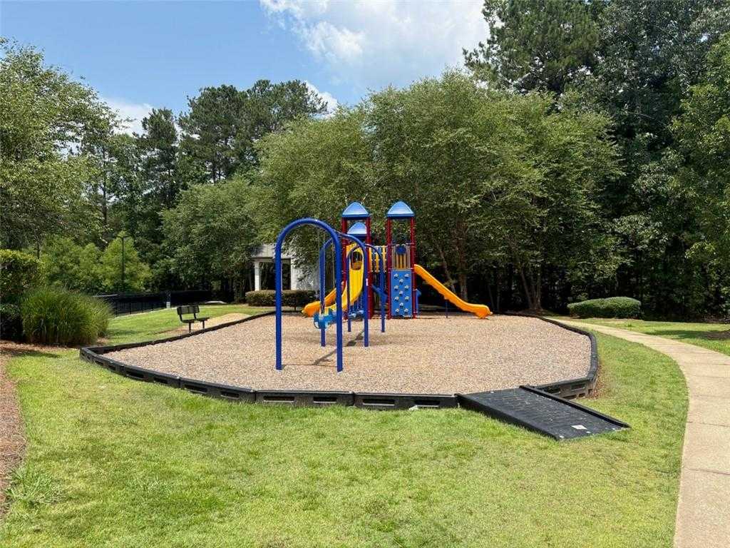 Vibrant playground with blue towers, yellow slides, swings, and gazebo amid lush trees in Riverwood, Dallas, Georgia