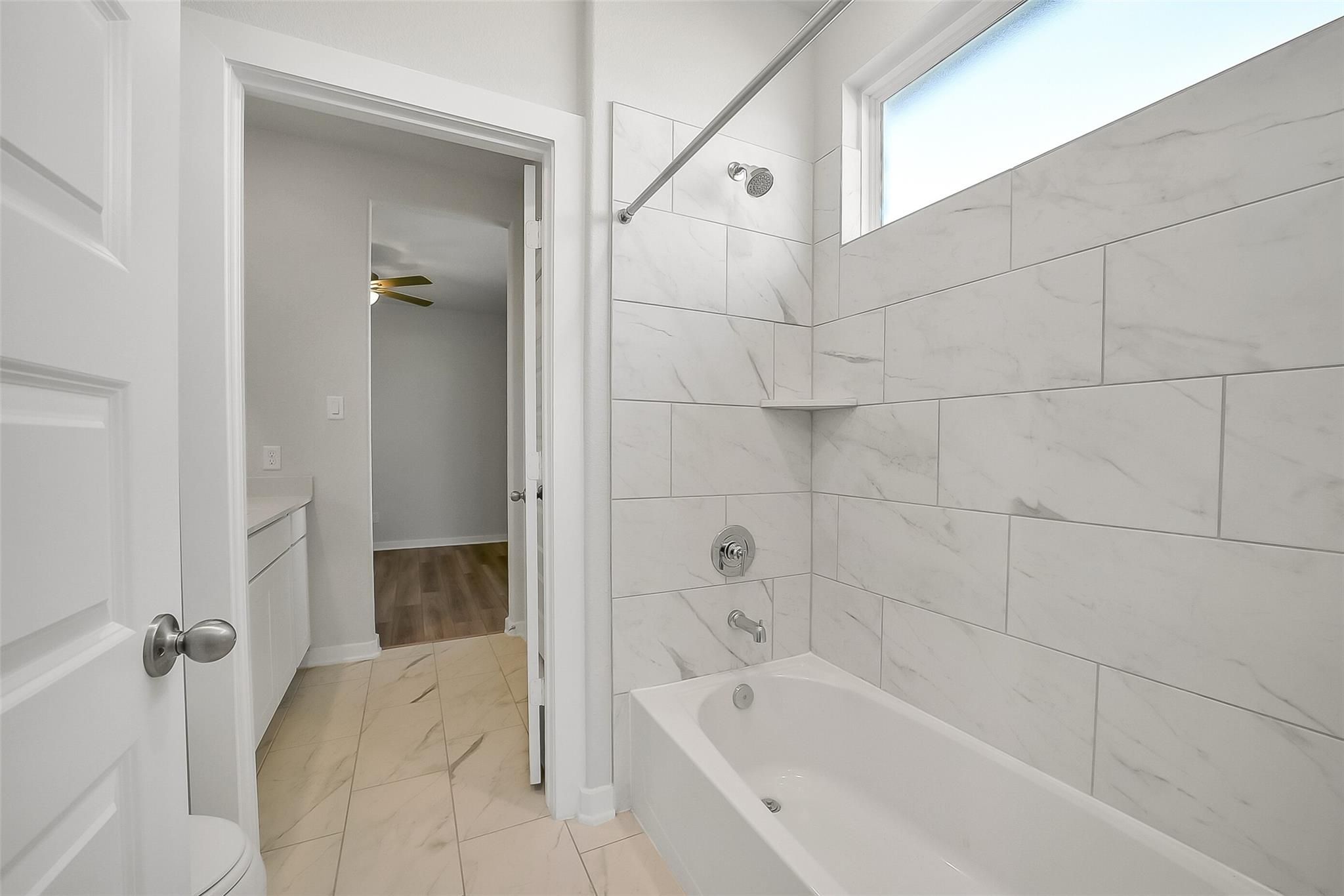 Modern bathroom with white subway tile shower, soaking tub, and vanity in Davidson Homes The Acadia A, Sunterra, Katy, Texas