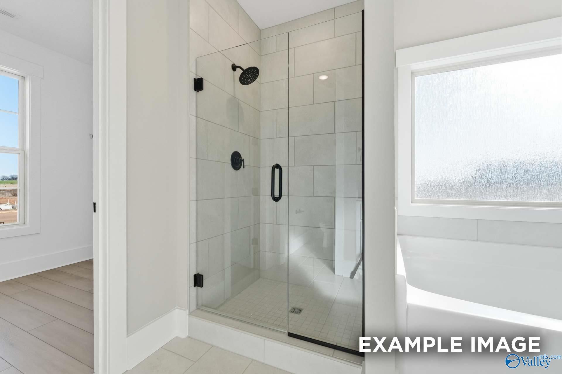 Modern frameless glass shower with rainfall head and subway tiles in The Emory master bath, Davidson Homes, Decatur AL