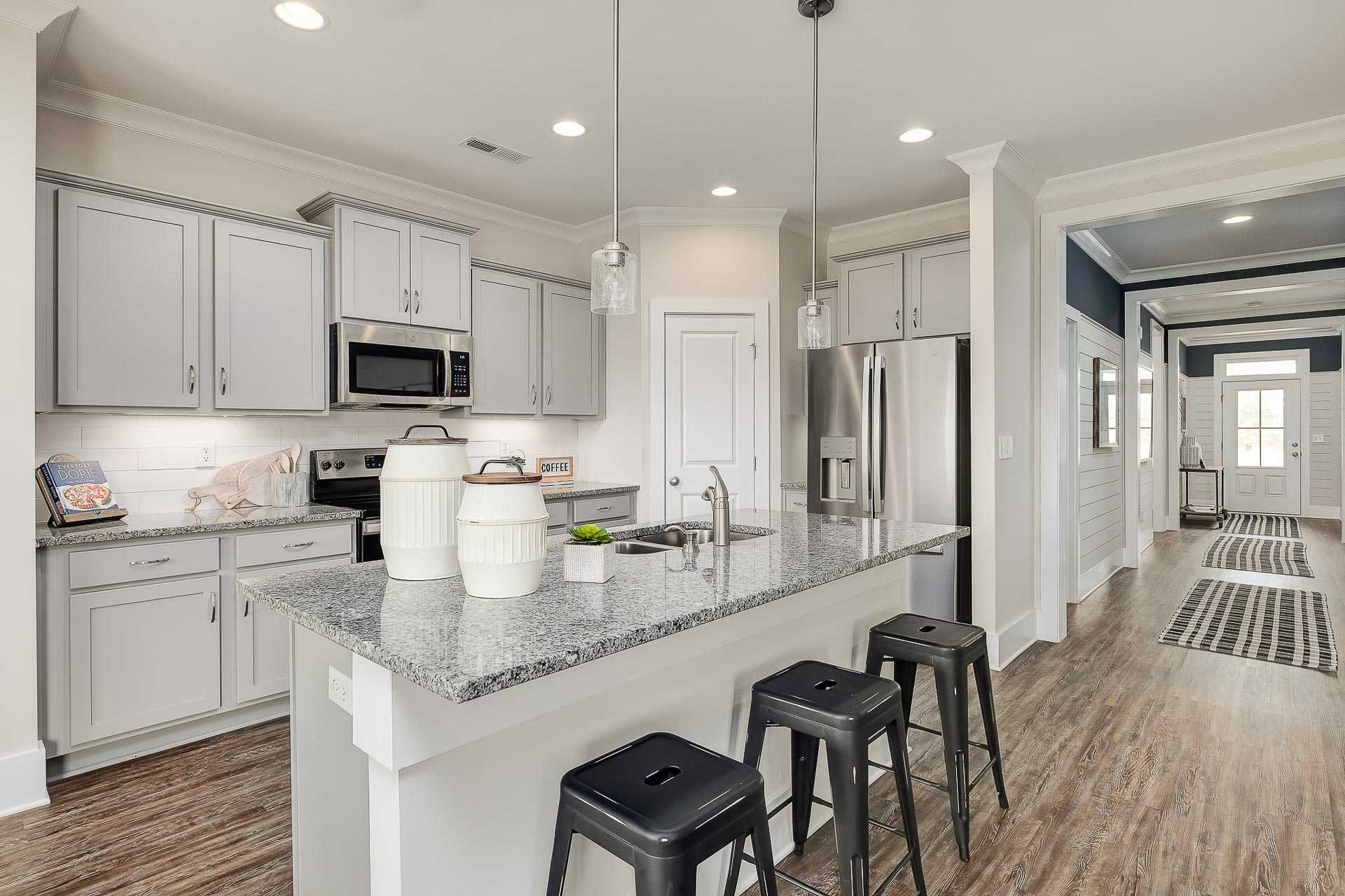 kitchen island with stools and light-colored flooring in Cullman, AL at The Reserve at North Ridge