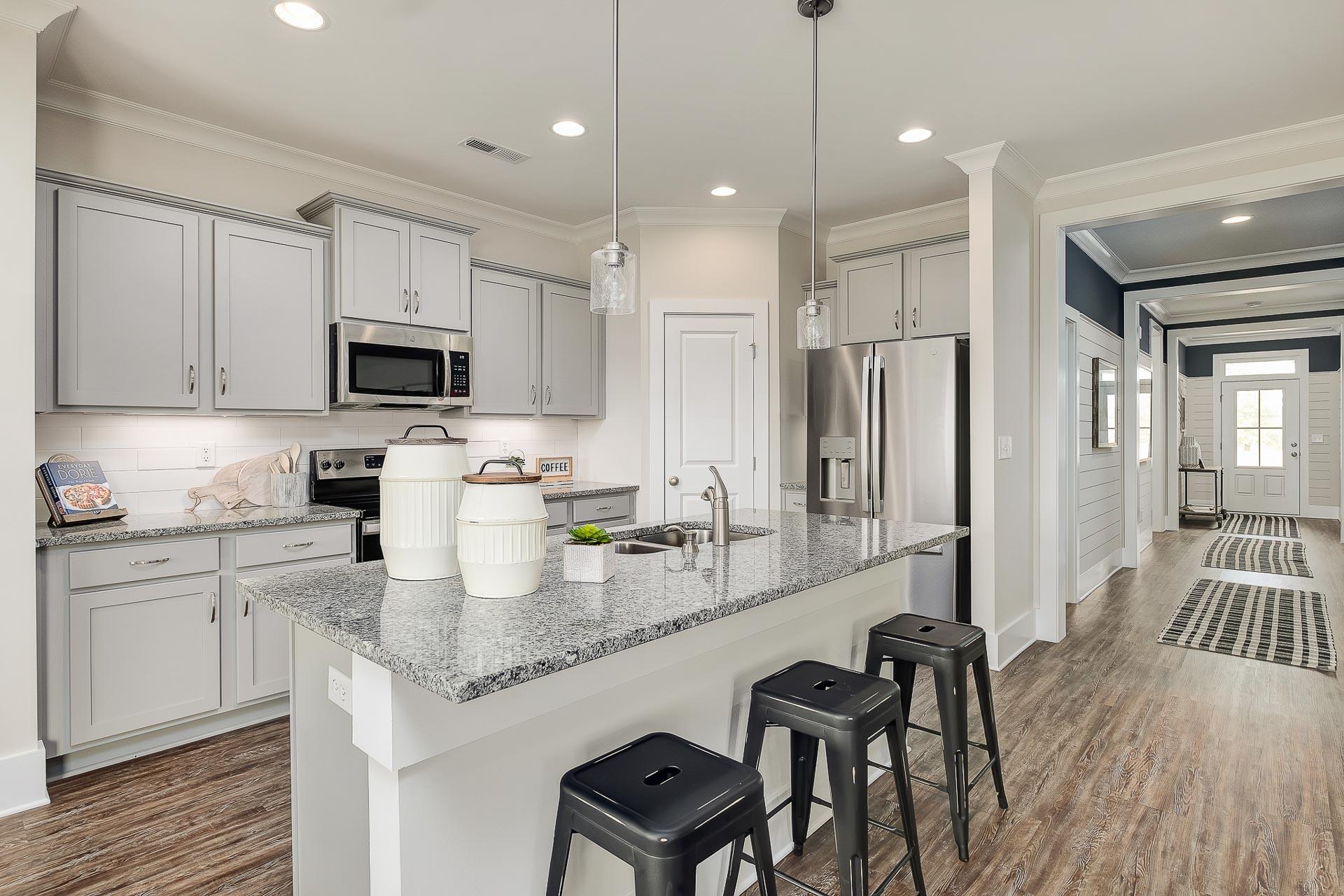 kitchen island with stools and light-colored flooring in Cullman, AL at The Reserve at North Ridge