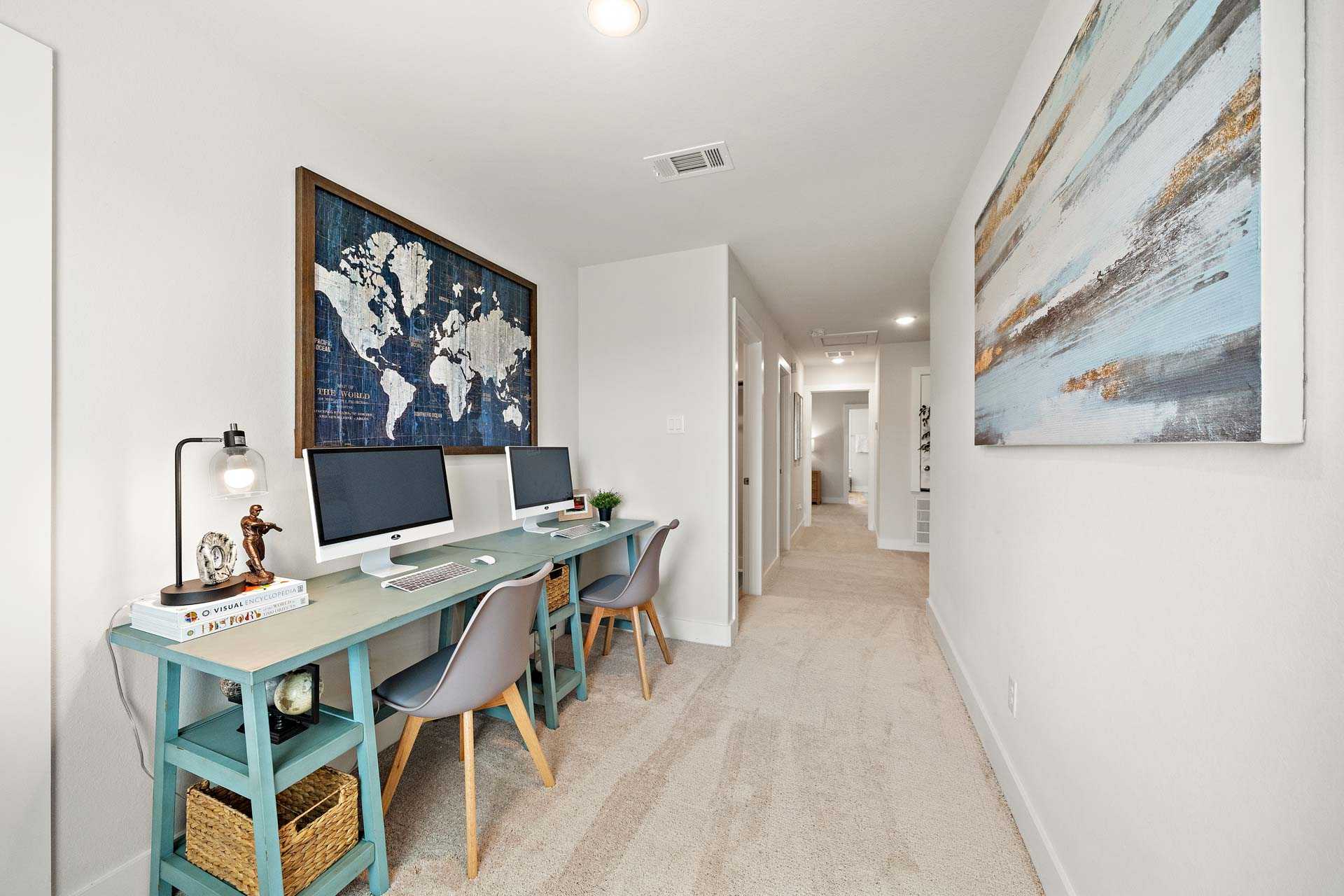 Spacious home office at Haven at Kieth Harrow in Cypress TX with dual monitors, world map wall art, and ergonomic chairs