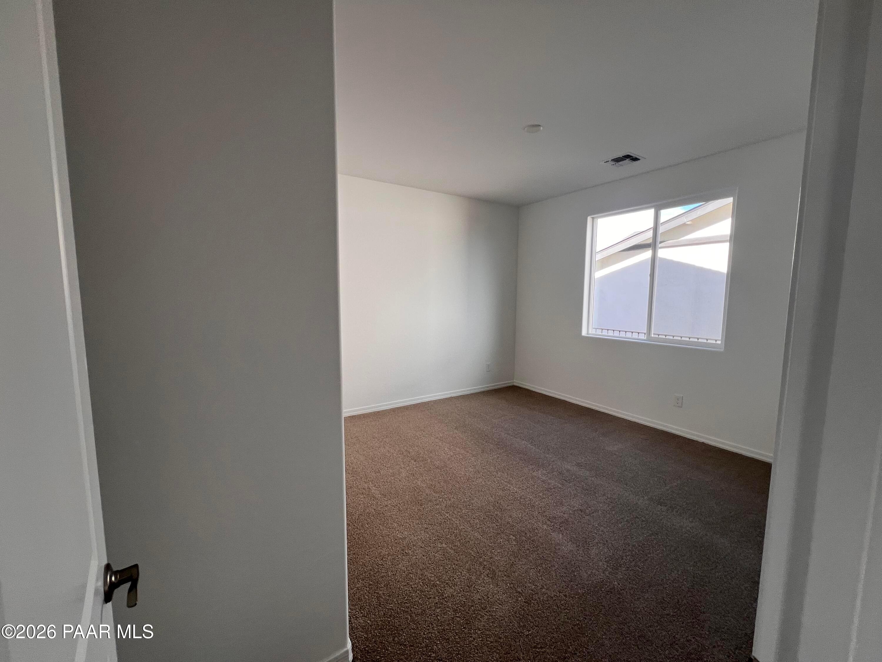 Spacious empty bedroom with beige carpet and large window in Davidson Homes The Monarch A, Westwood, Prescott, Arizona