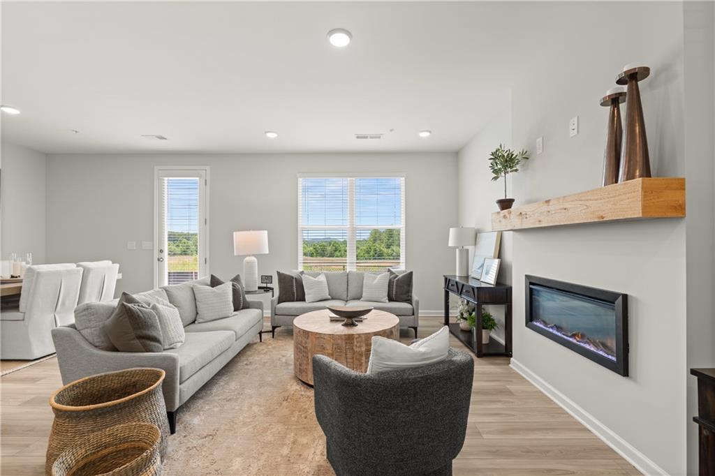 Modern living room with fireplace and wood mantel in The Wake B floor plan at Hemingway in Cumming, Georgia.