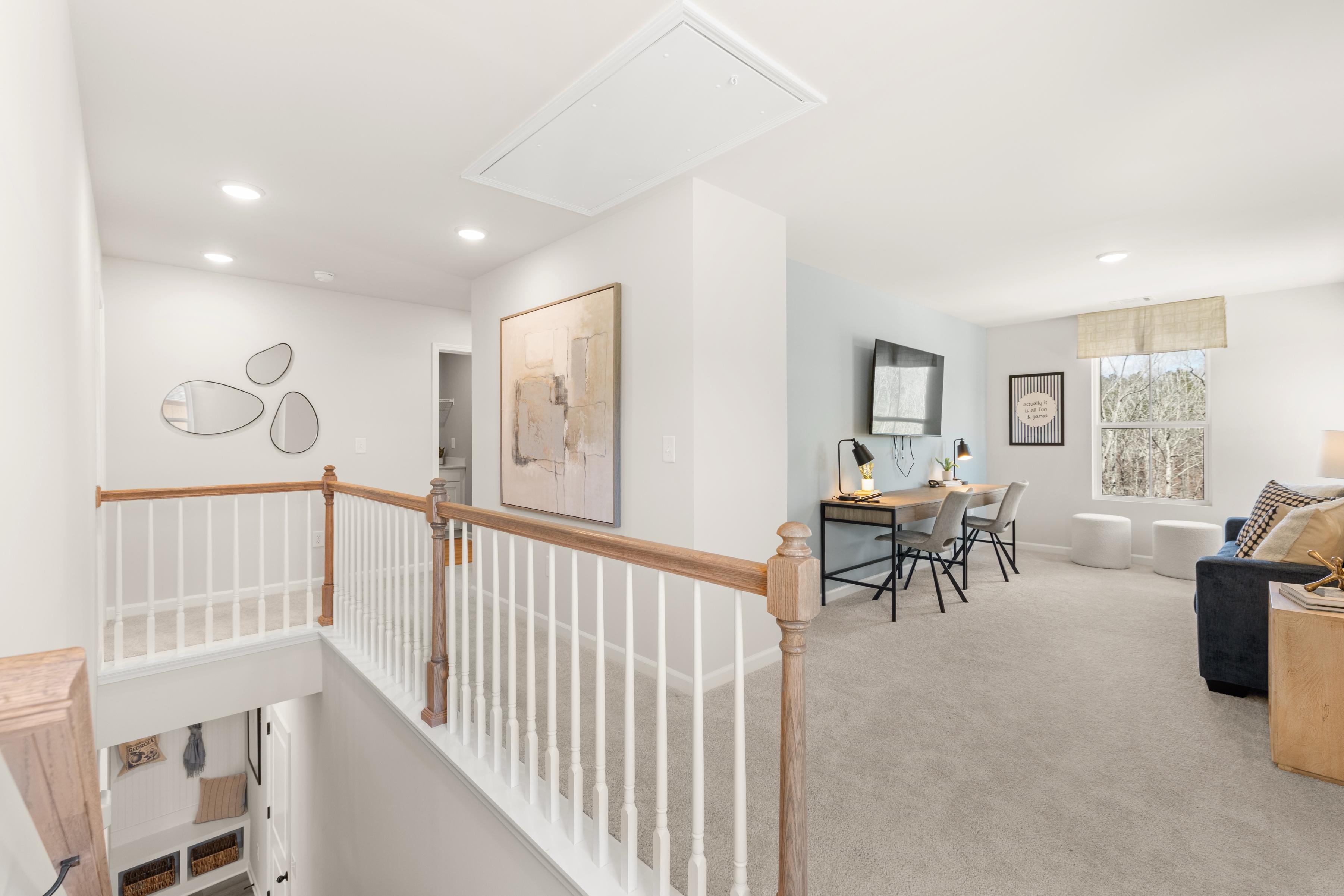 Spacious loft area at Links Crossing in Auburn, AL by Davidson Homes featuring a home office space and lounge seating.