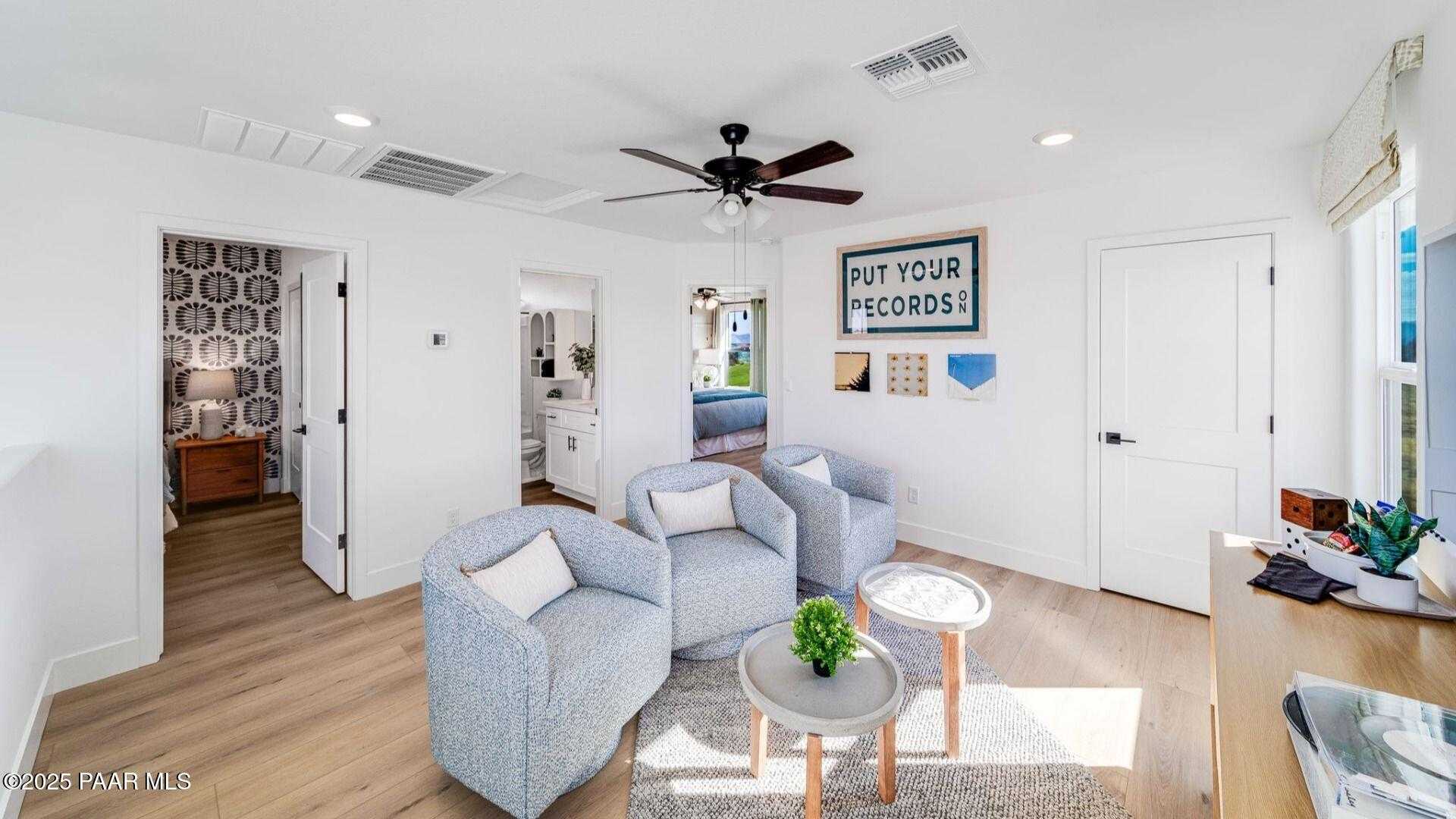 Cozy loft nook with light blue armchairs, potted plant table, and desk in Davidson Homes The Wilmington B, Prescott, Arizona