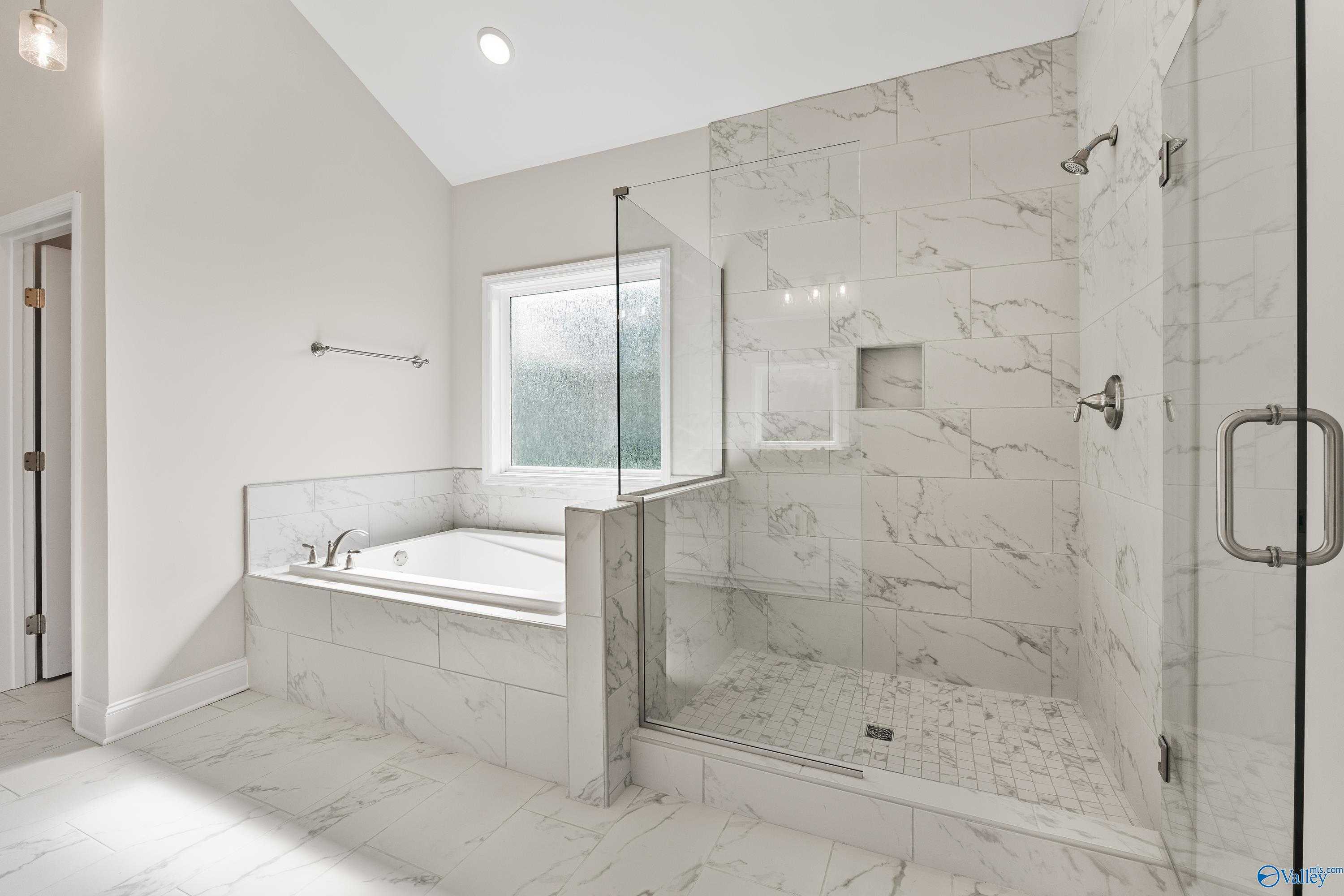 Elegant master bathroom featuring freestanding tub, glass-enclosed marble shower in Davidson Homes The Finleigh, Toney, Alabama