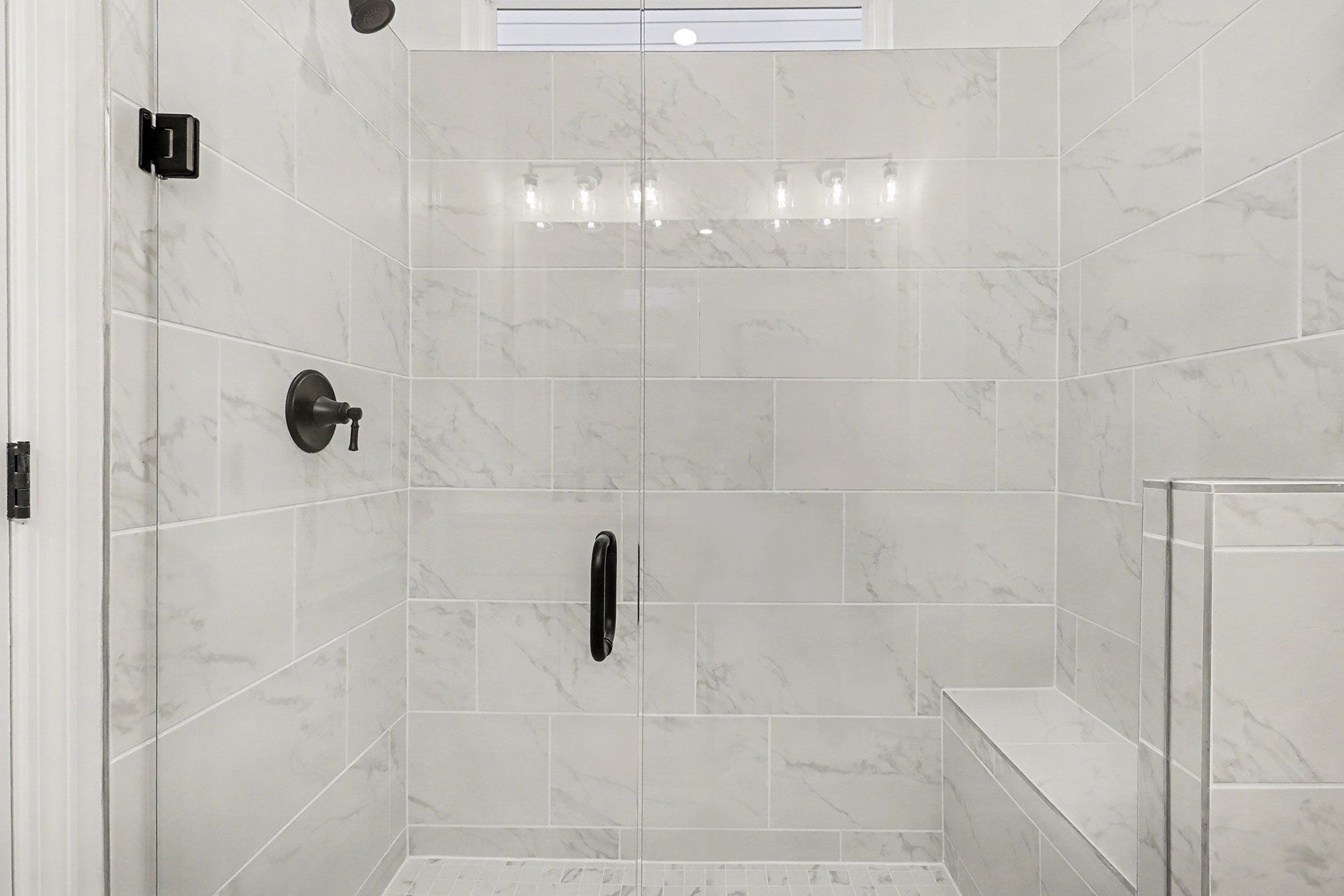 Modern master bathroom with frameless glass shower, white subway tile, and adjacent bedroom in Davidson Homes The Daphne B, Loganville, GA