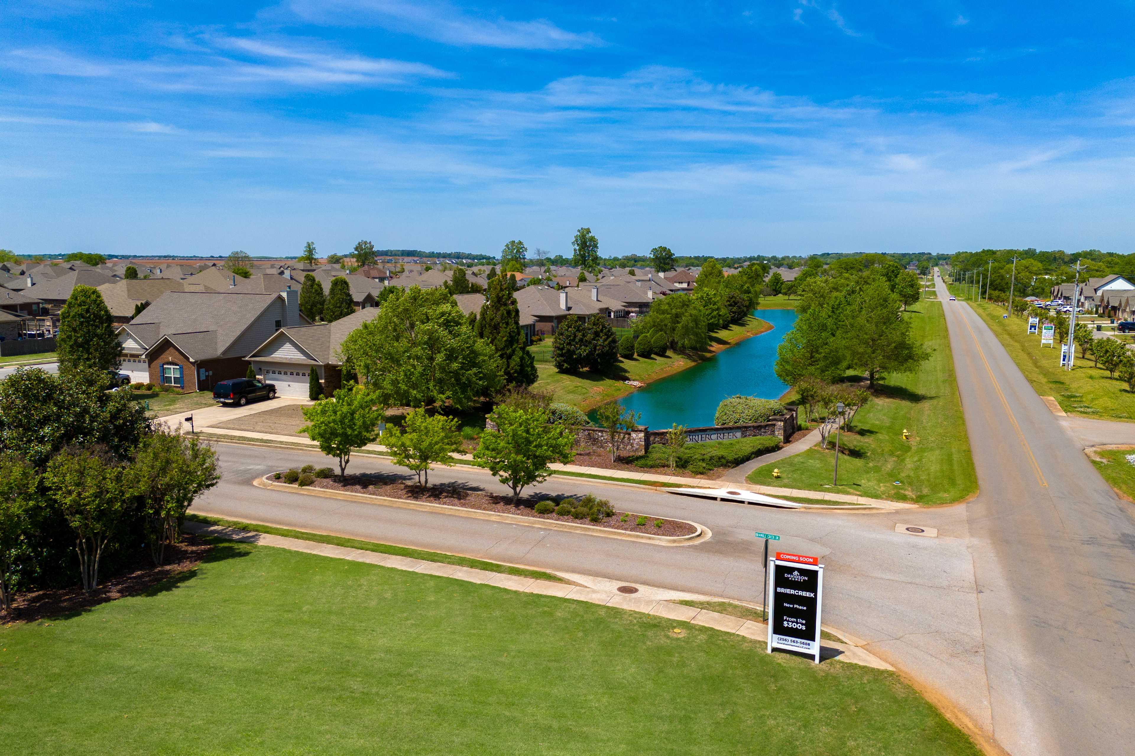 Aerial view of Briercreek neighborhood in Meridianville AL with homes, scenic creek, lush trees and community sign