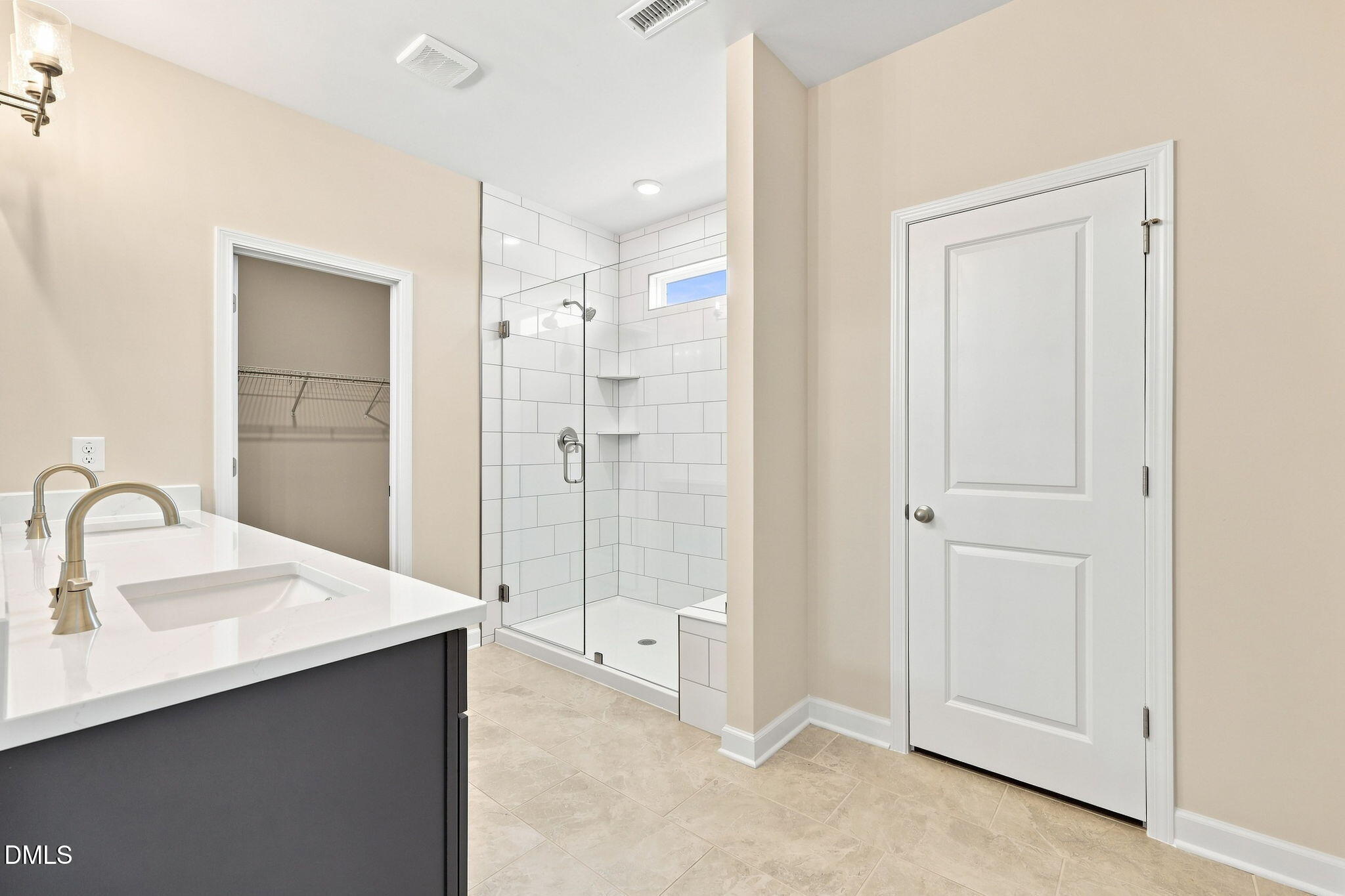 Modern primary bathroom with glass-enclosed subway tile shower in The Magnolia B floor plan at Retreat at North Main.