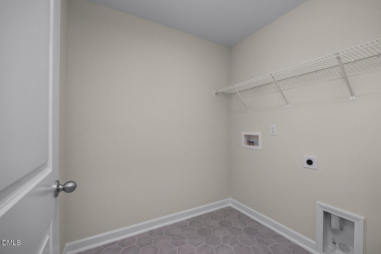 Laundry room with tile flooring and wire shelving in The Mitchell floor plan at Camden Park, Knightdale, North Carolina.