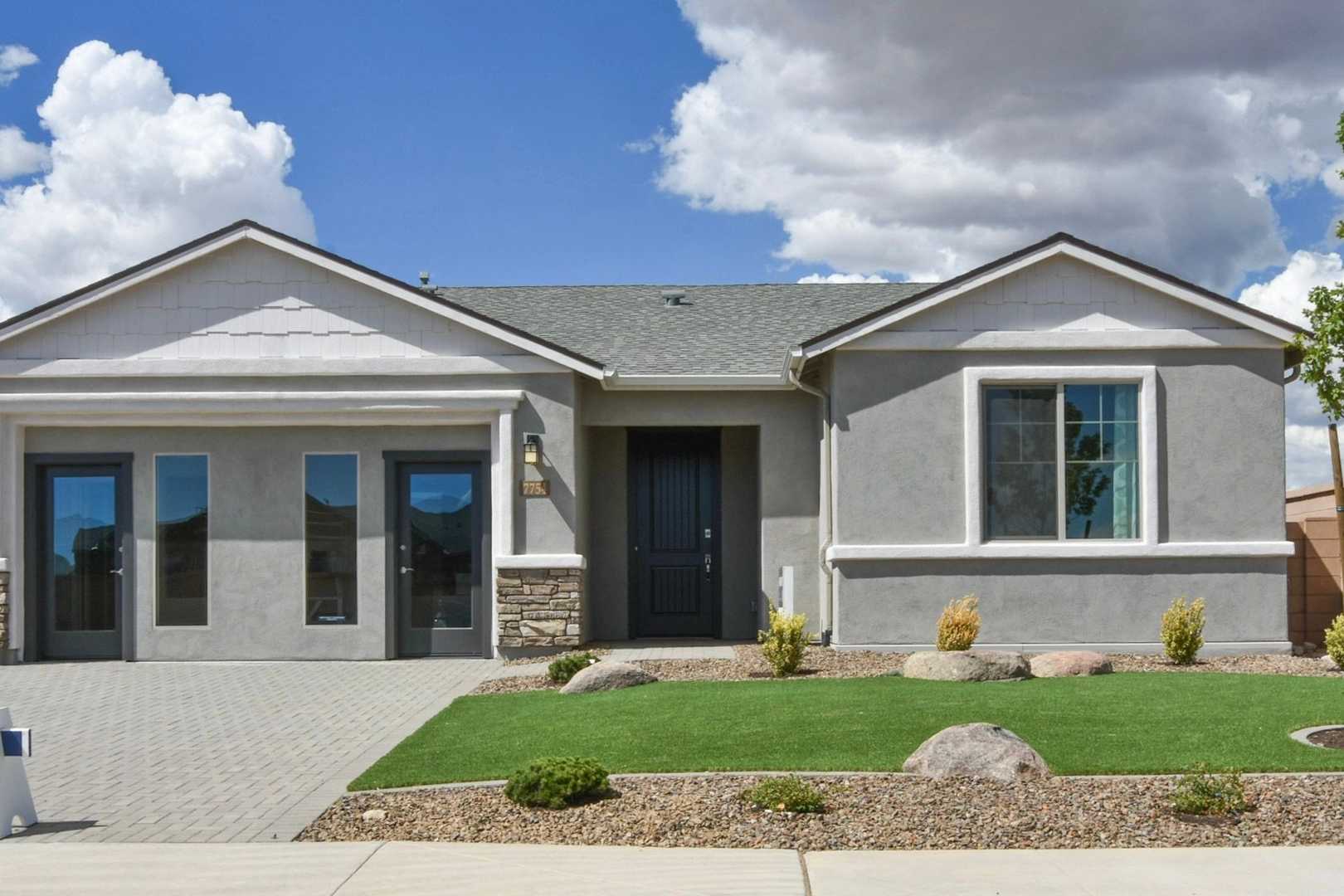 Modern single-story Harmony home exterior with 3-car garage, stone accents, and desert landscaping in Prescott Valley