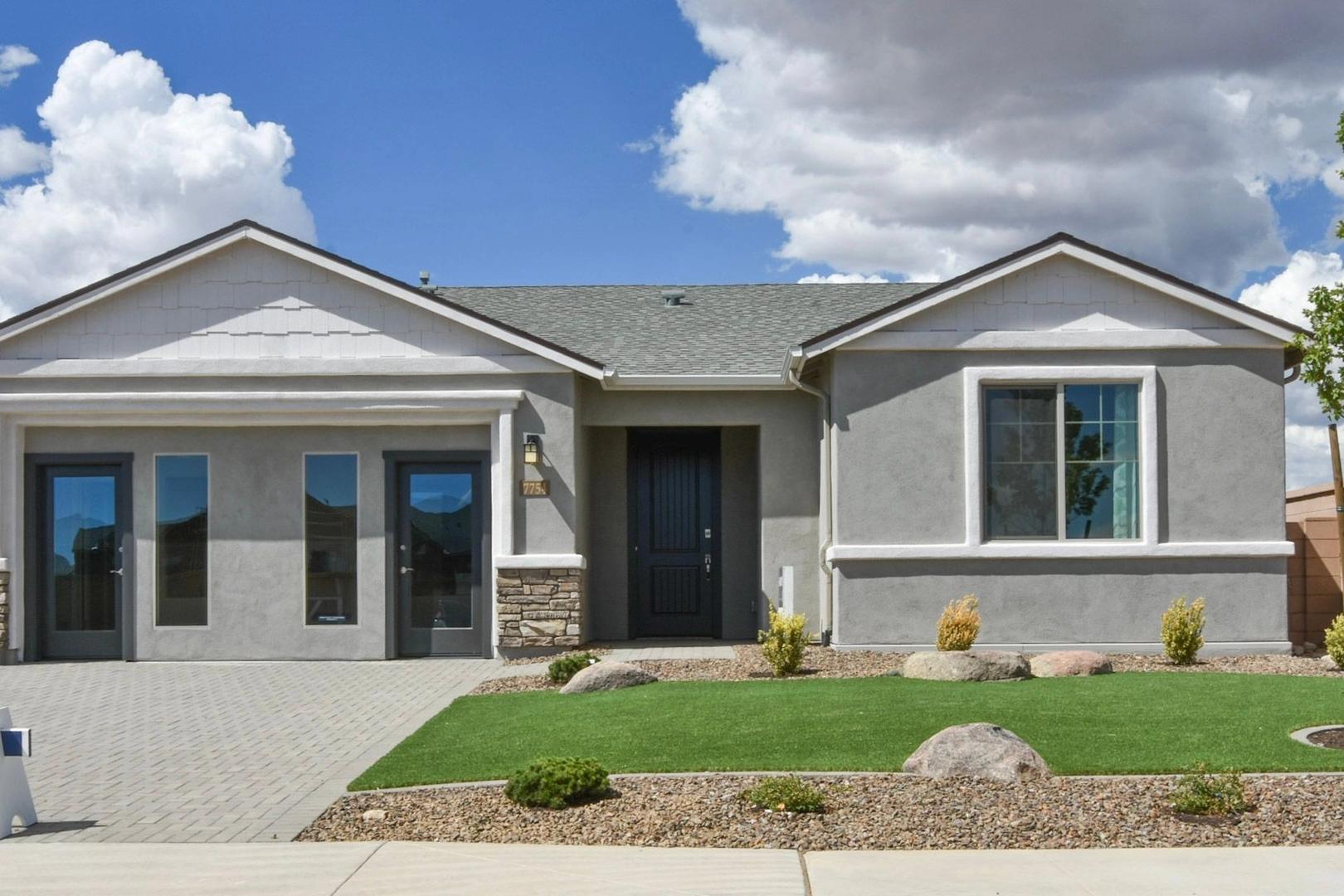 Modern single-story Harmony home exterior with 3-car garage, stone accents, and desert landscaping in Prescott Valley