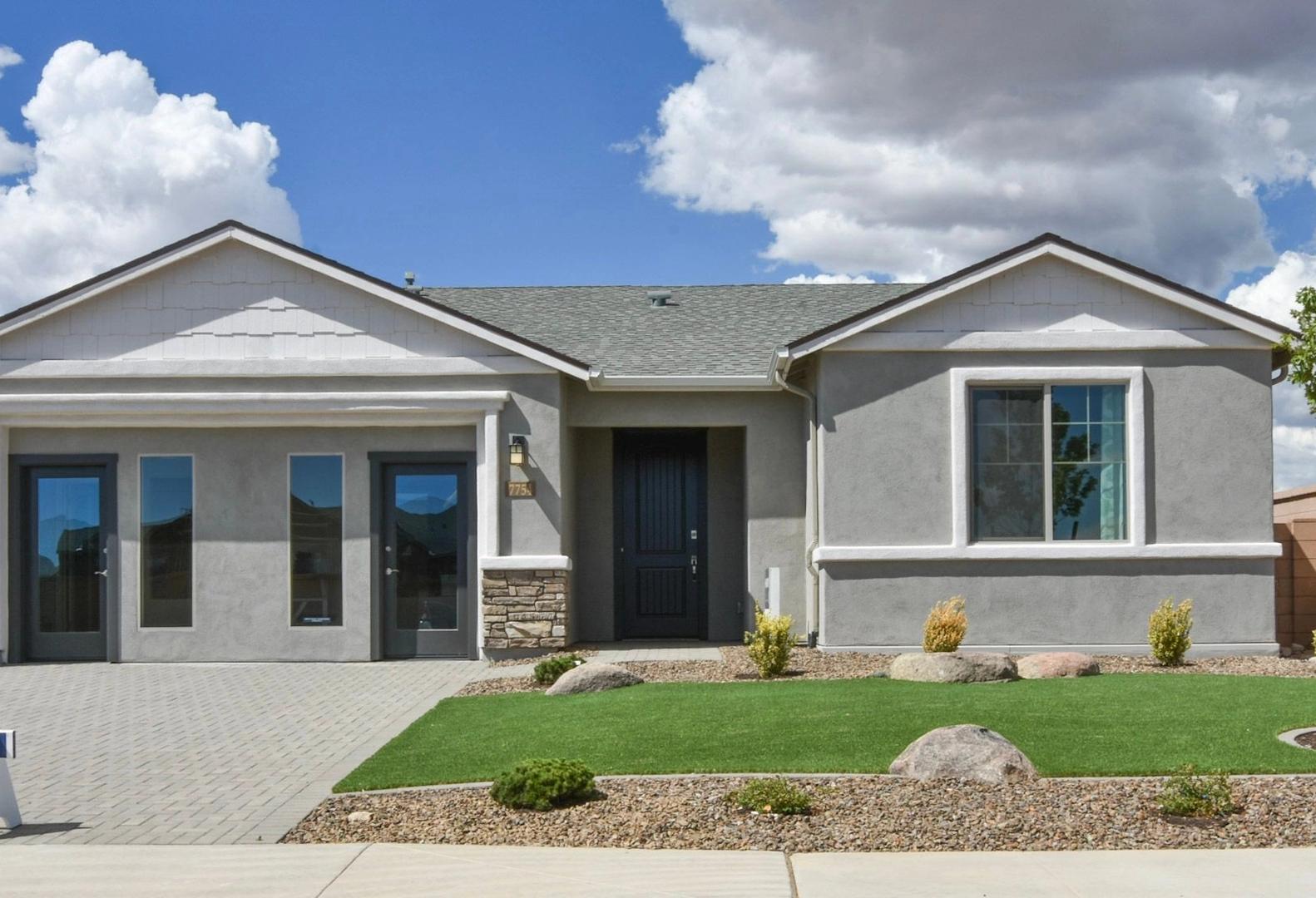 Modern single-story Harmony home exterior with 3-car garage, stone accents, and desert landscaping in Prescott Valley