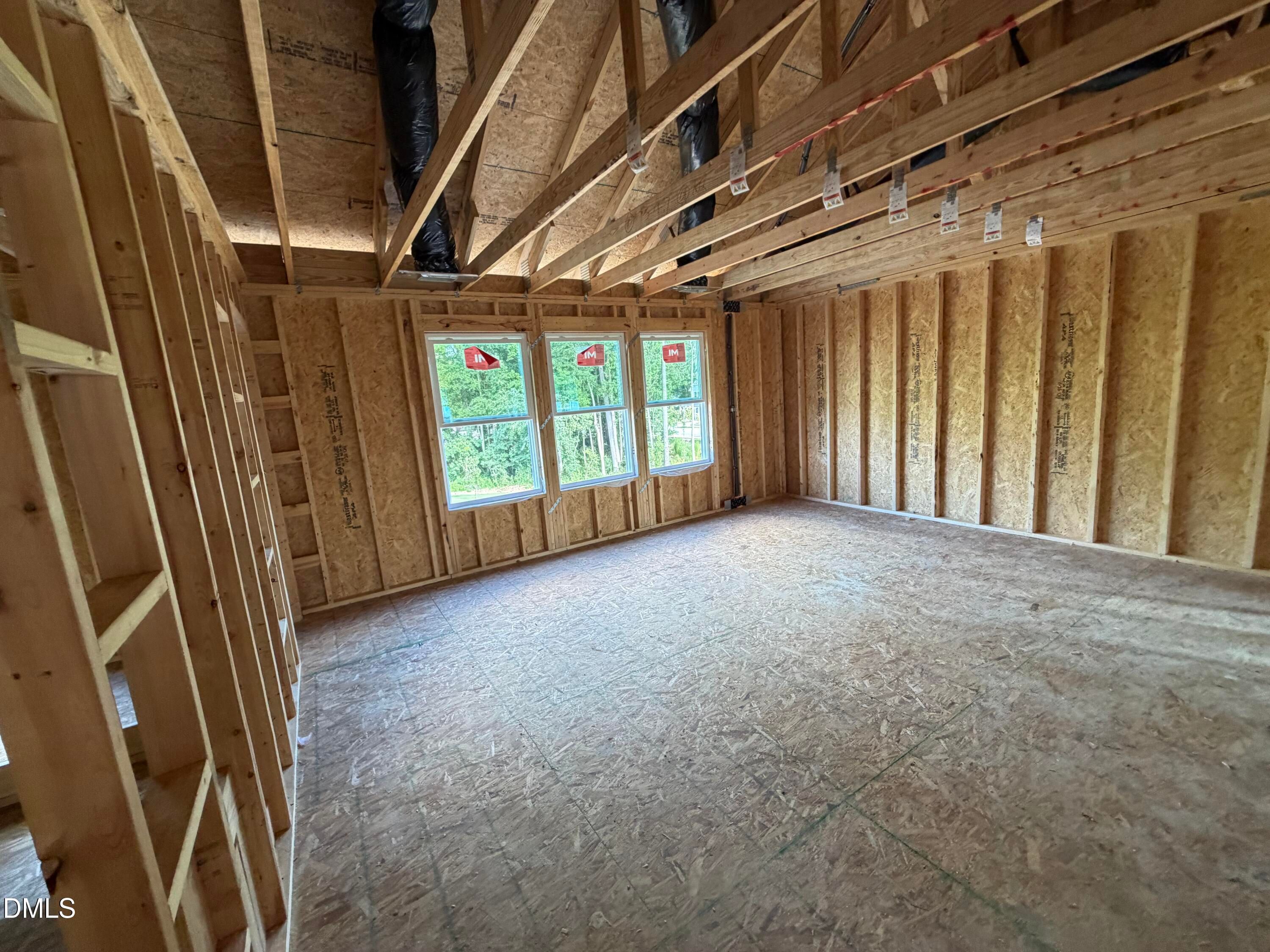 Unfinished framed bonus room with vaulted ceiling and windows in Davidson Homes The Beech new construction, Wendell, NC