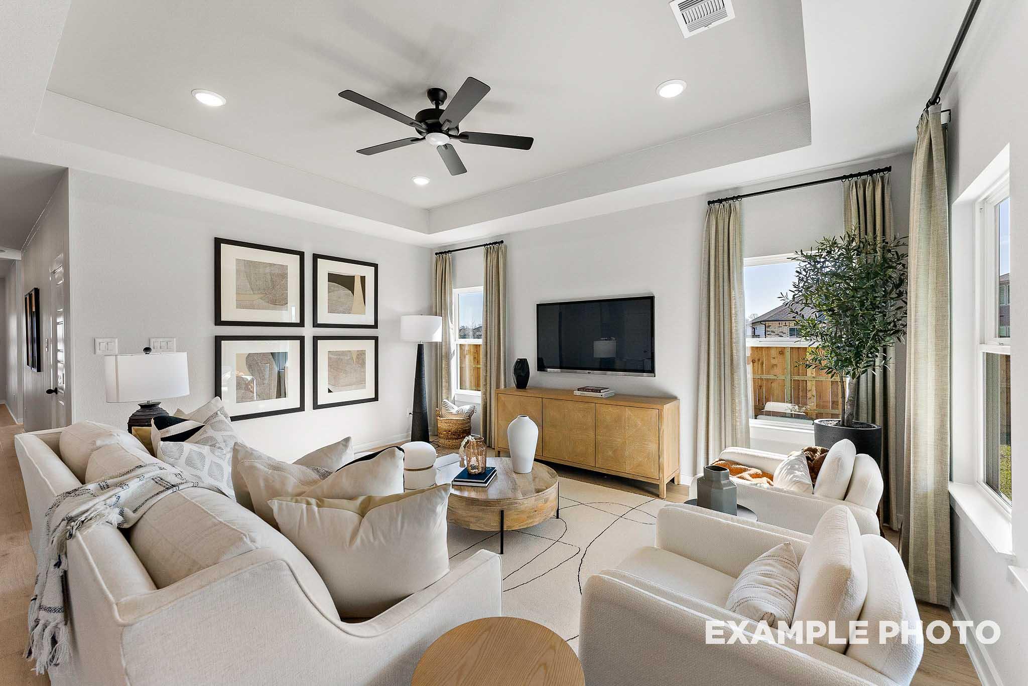 Bright, open-concept living room with tray ceiling in The Everett E floor plan by Davidson Homes in Sundance Cove, Crosby.
