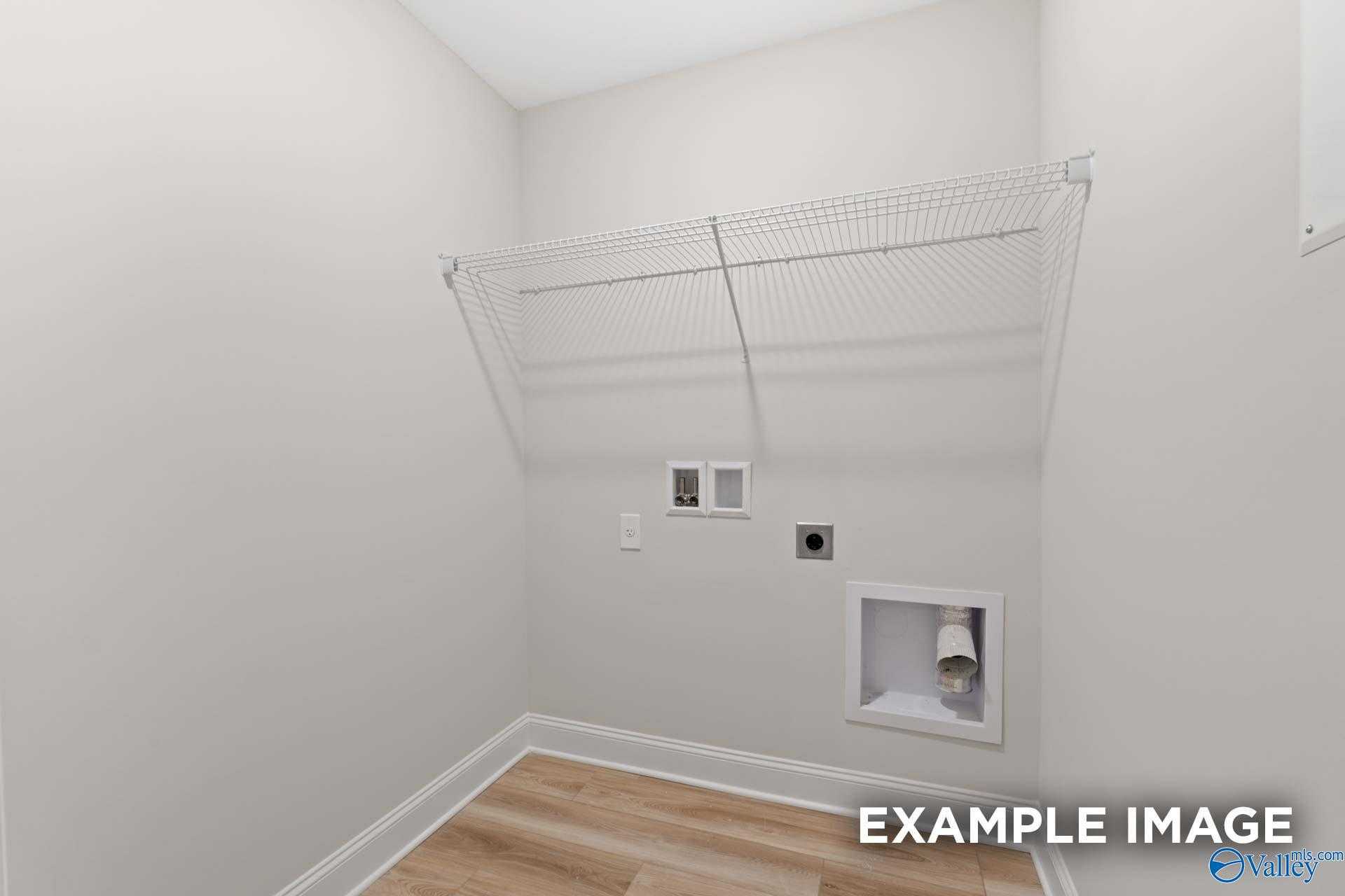 Bright laundry closet with wire shelving, utility outlets and dryer vent in Davidson Homes The Camden, Huntsville, AL