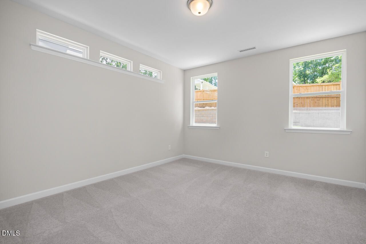 Bright, carpeted bedroom with natural light in The Ashport G floor plan at Sage on North Main, Wake Forest, NC.