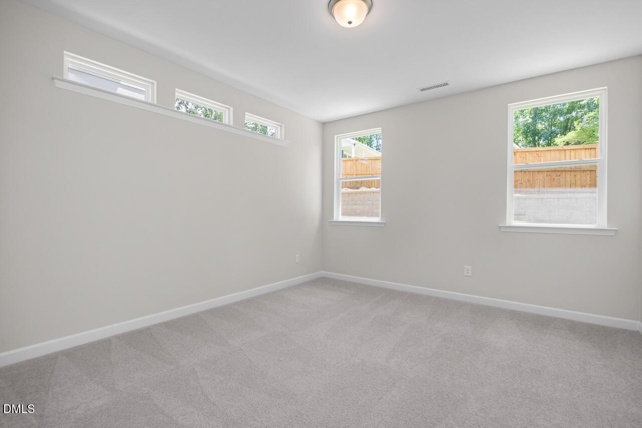 Bright, carpeted bedroom with natural light in The Ashport G floor plan at Sage on North Main, Wake Forest, NC.