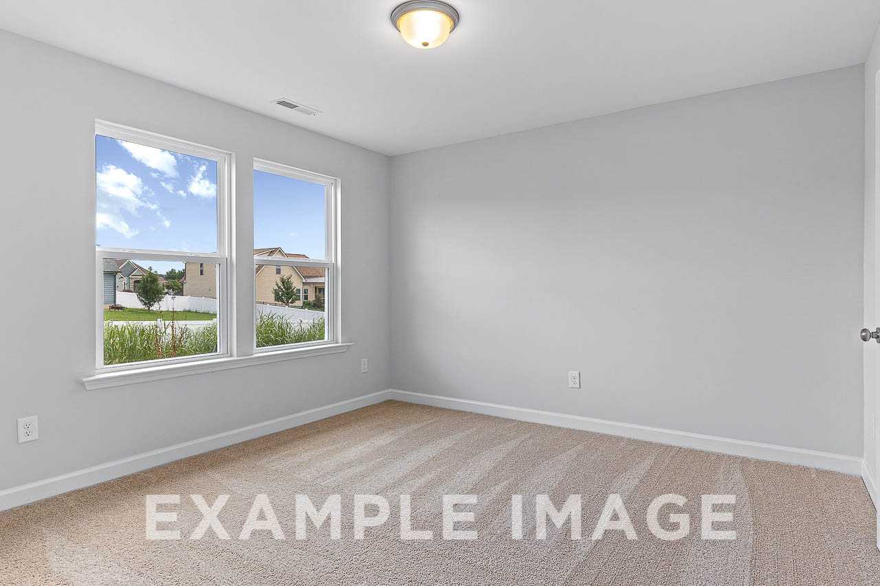 Bright upstairs bedroom in The Willow C with light gray walls, beige carpet, large windows overlooking Wendell neighborhood