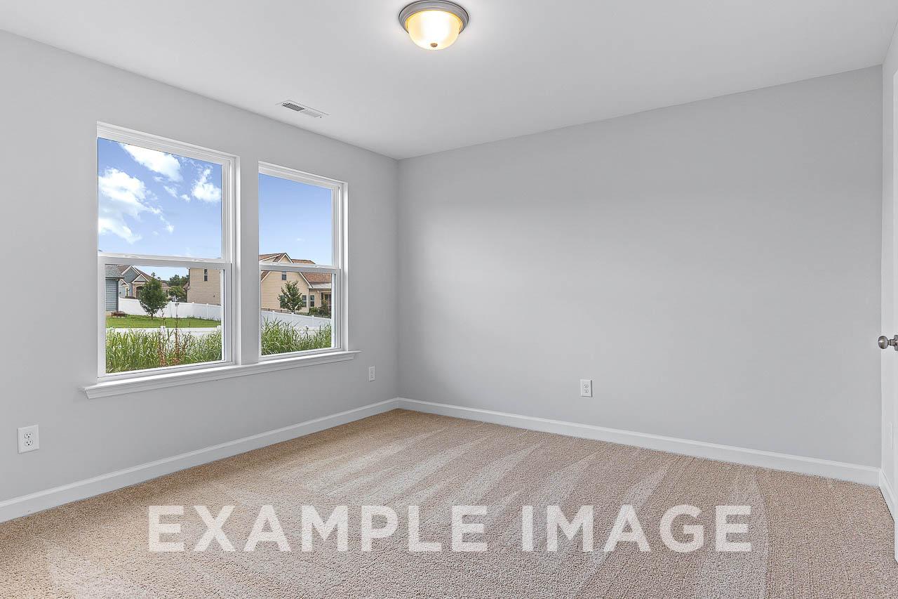 Bright upstairs bedroom in The Willow C with light gray walls, beige carpet, large windows overlooking Wendell neighborhood