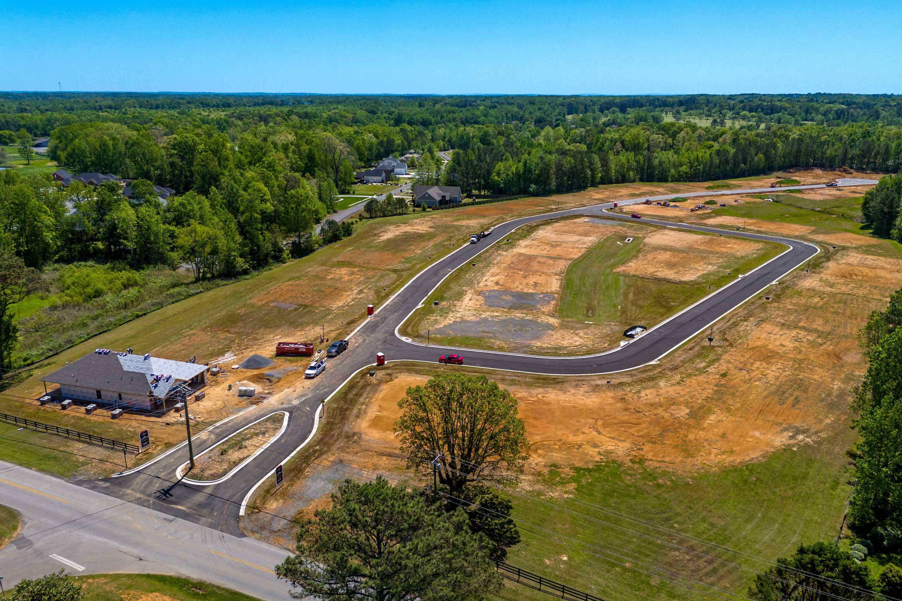 Aerial view of The Highlands neighborhood under construction in Arab Alabama by Davidson Homes with new roads and wooded terrain