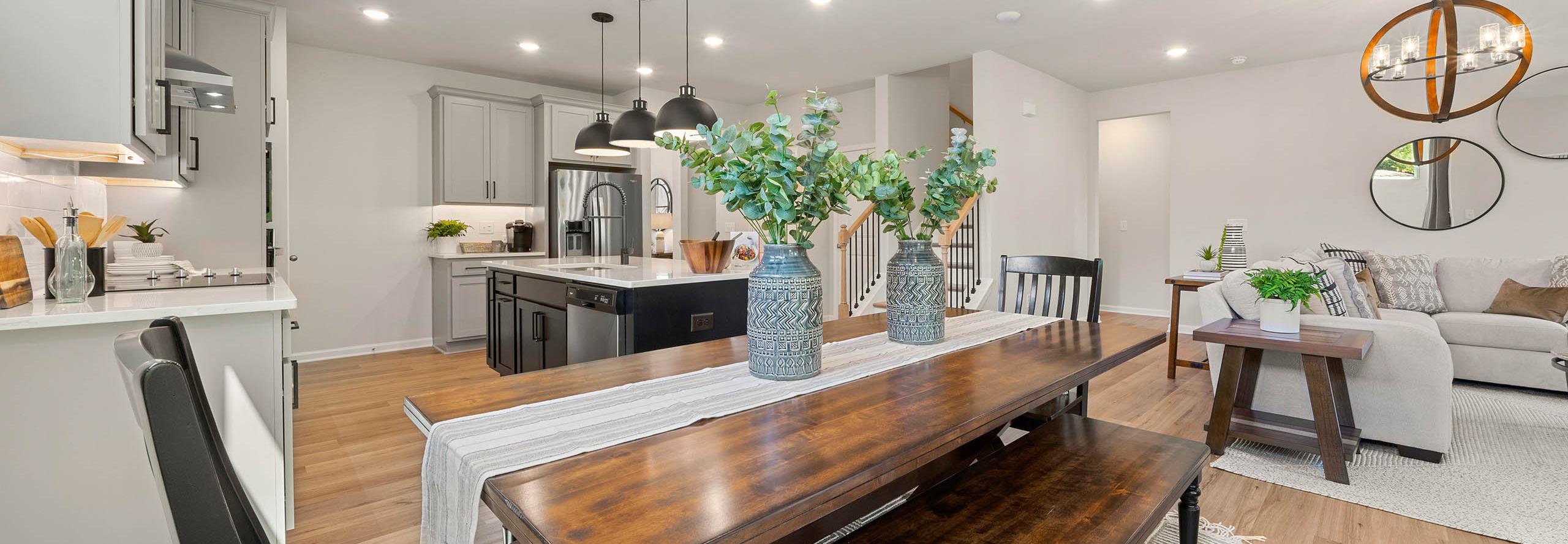 Open-concept kitchen dining area at Mountainbrook in Cartersville GA by Davidson Homes with white cabinets wooden table benches eucalyptus