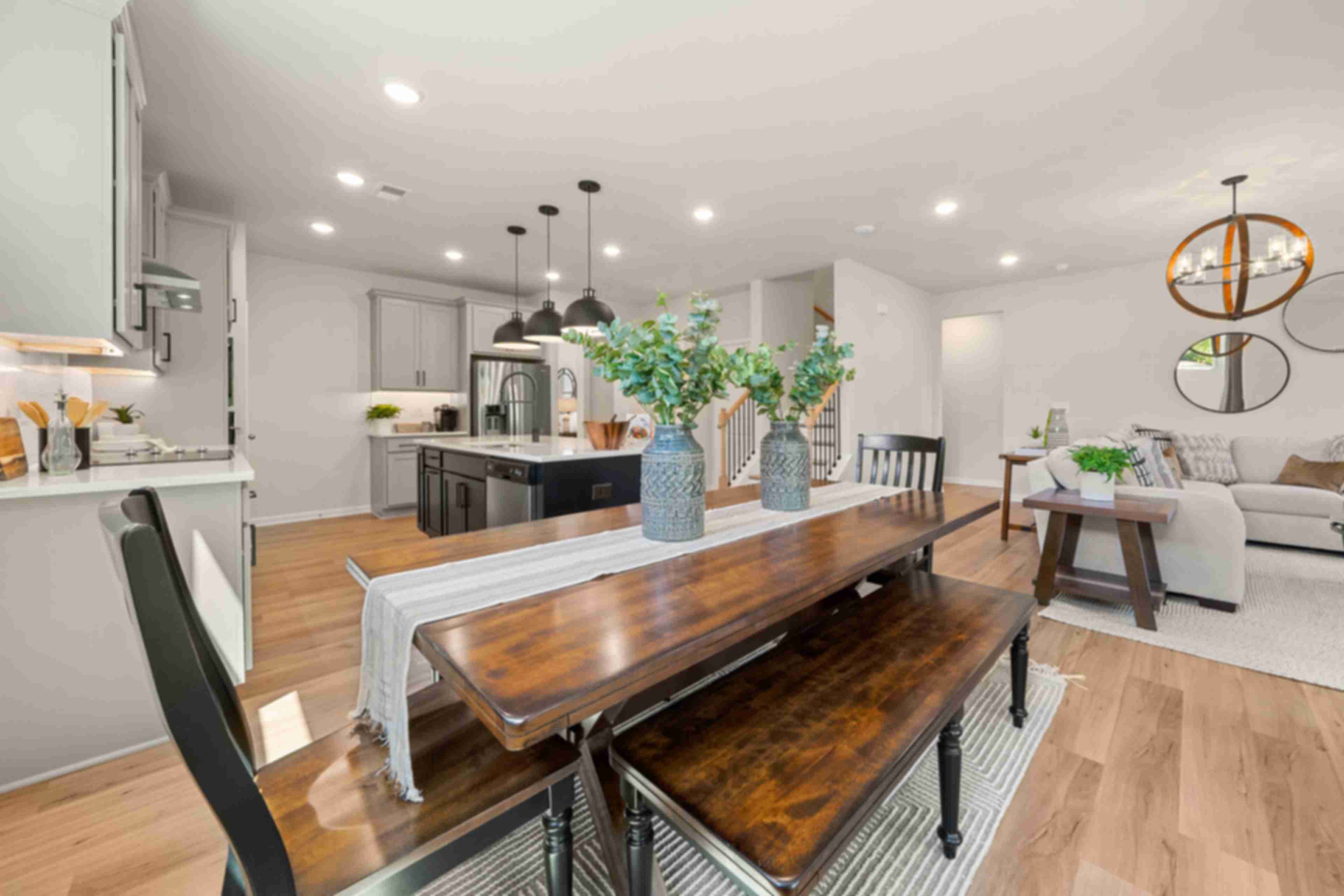 Open-concept kitchen dining area at Mountainbrook in Cartersville GA by Davidson Homes with white cabinets wooden table benches eucalyptus