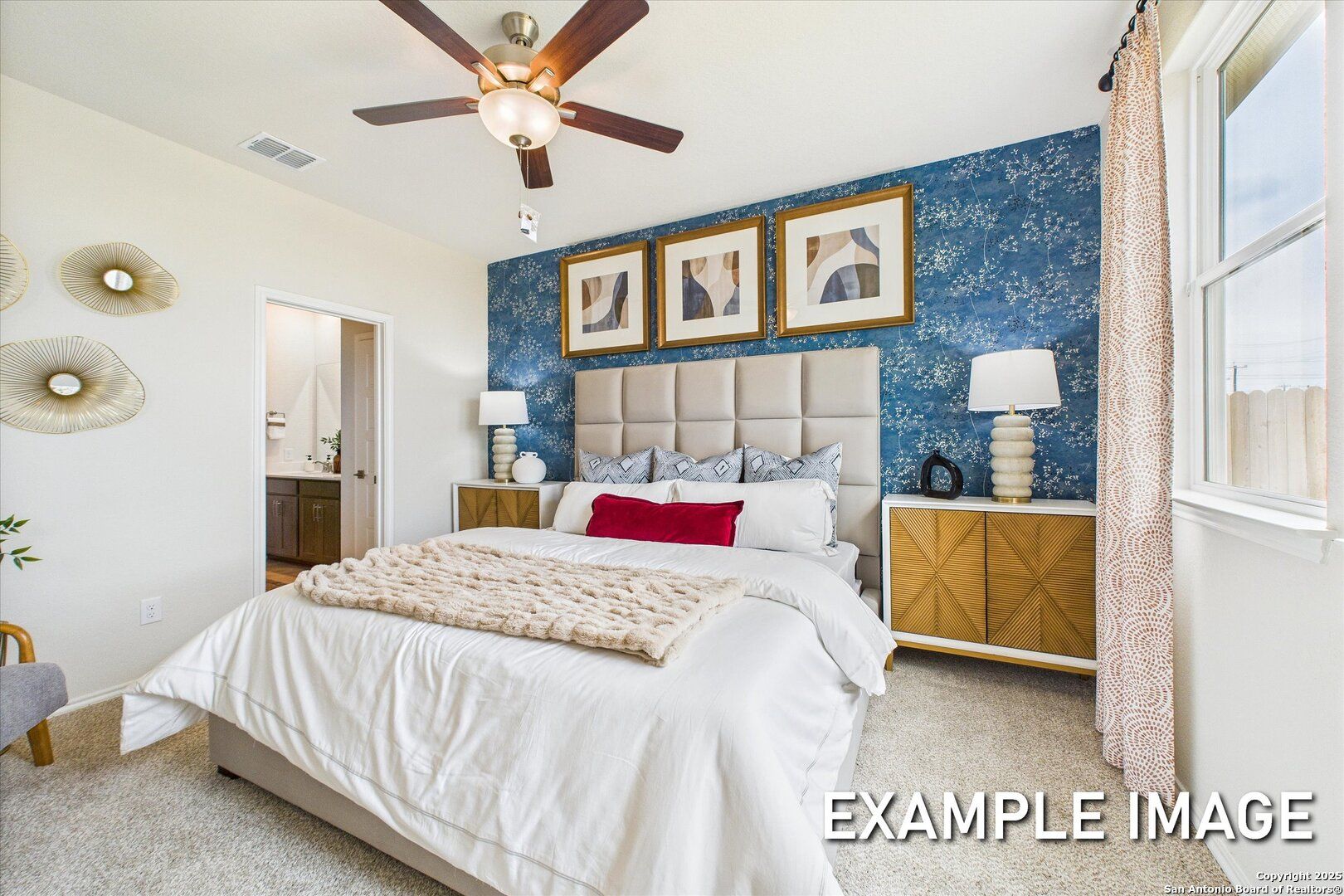 Elegant master bedroom with blue accent wall, tufted headboard, plush bedding, and ceiling fan in Davidson Homes The Brazos C, San Antonio