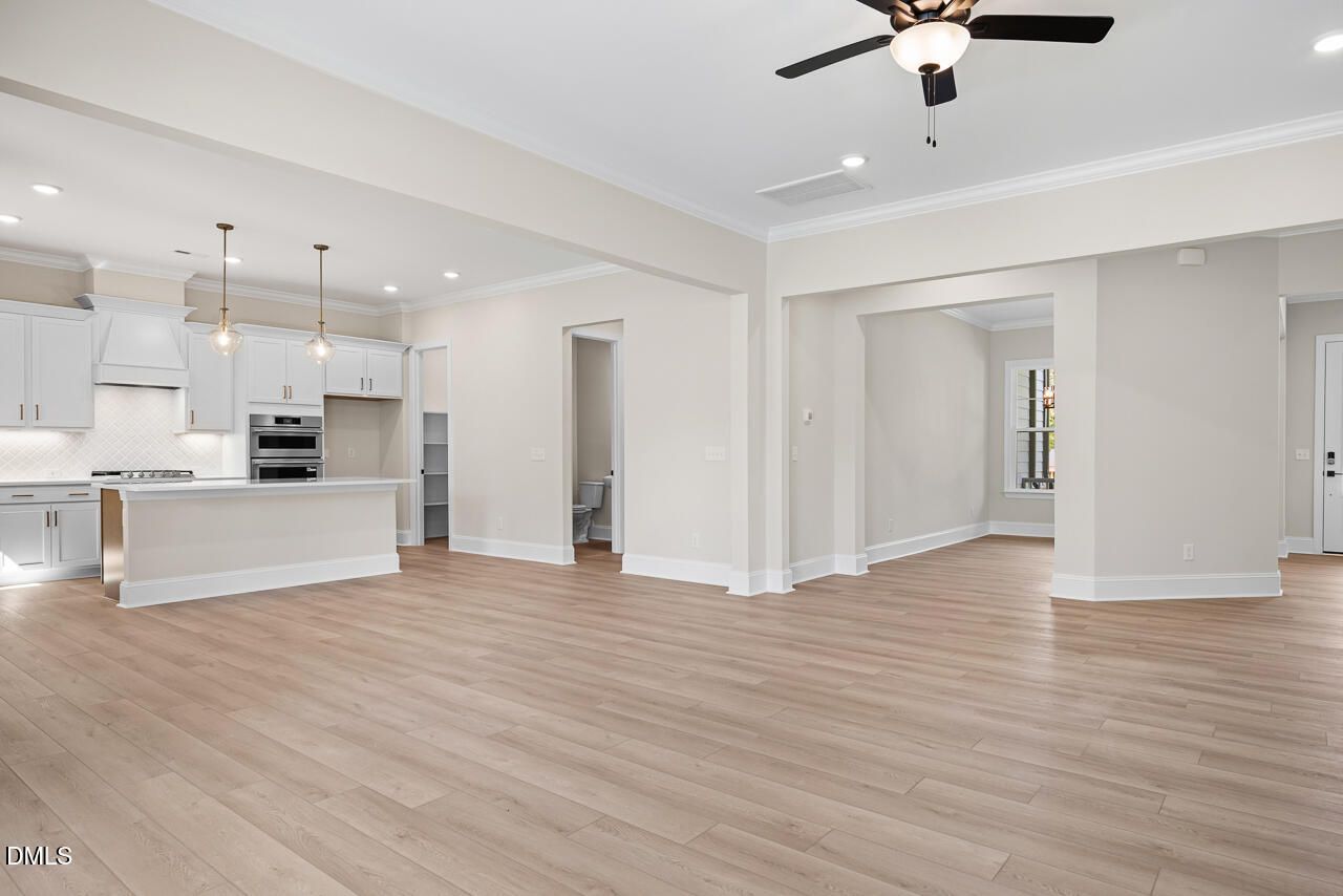 Open-concept living area with white kitchen, island, and hardwood floors in Davidson Homes Crawford D plan, Wake Forest, NC