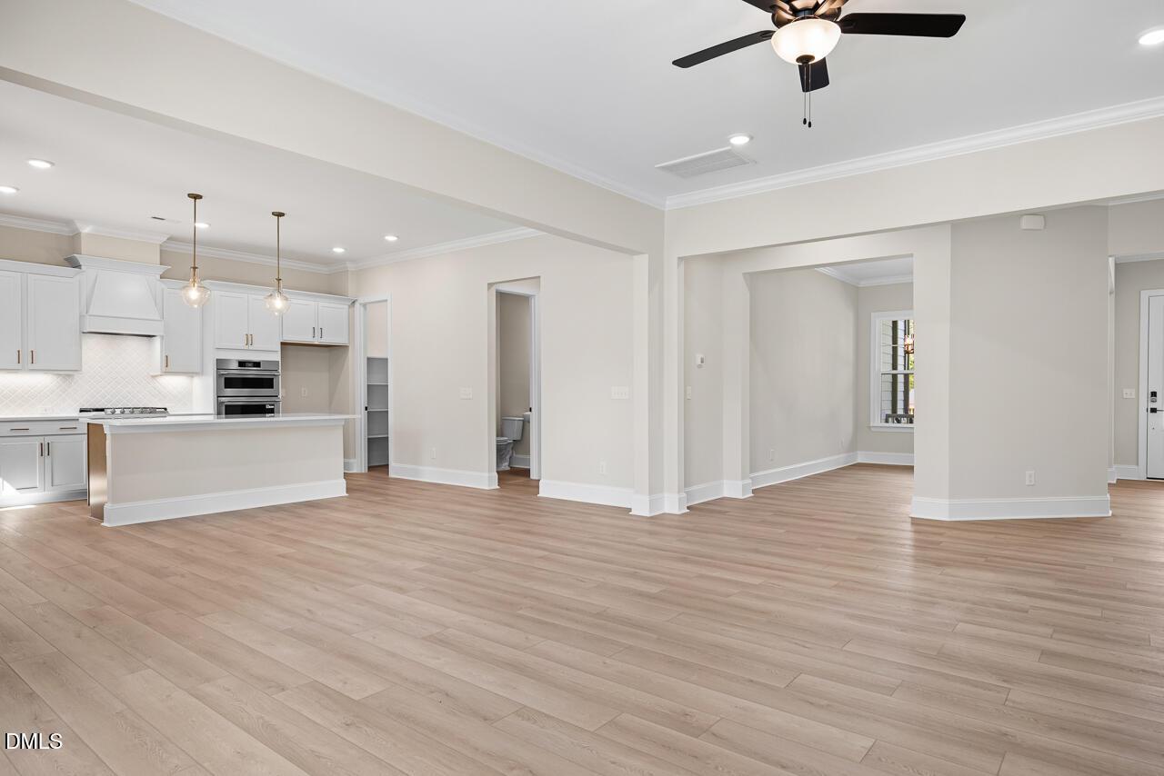Open-concept living area with white kitchen, island, and hardwood floors in Davidson Homes Crawford D plan, Wake Forest, NC