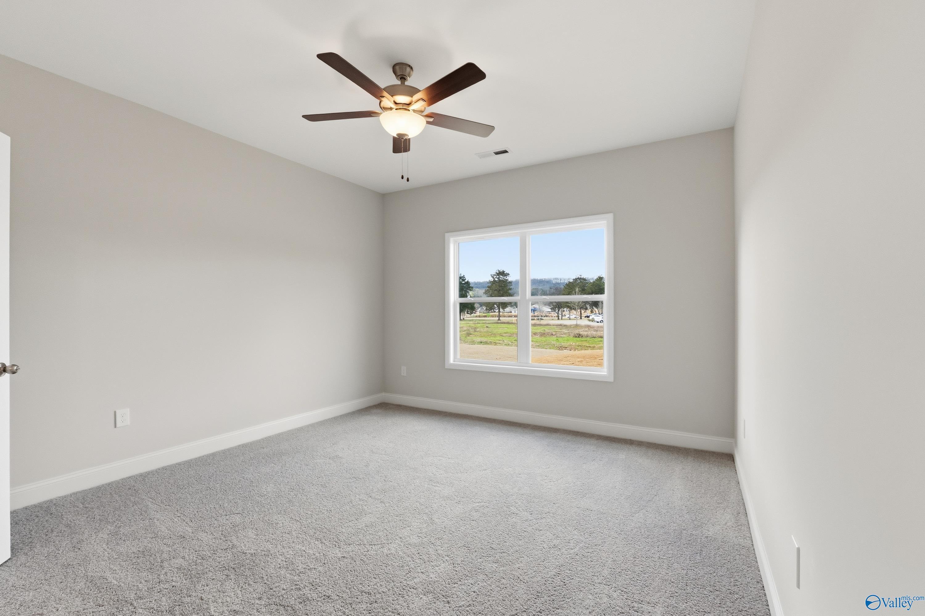 Bright secondary bedroom with ceiling fan and window overlooking grassy yard in Davidson Homes The Asheville C, Huntsville, AL