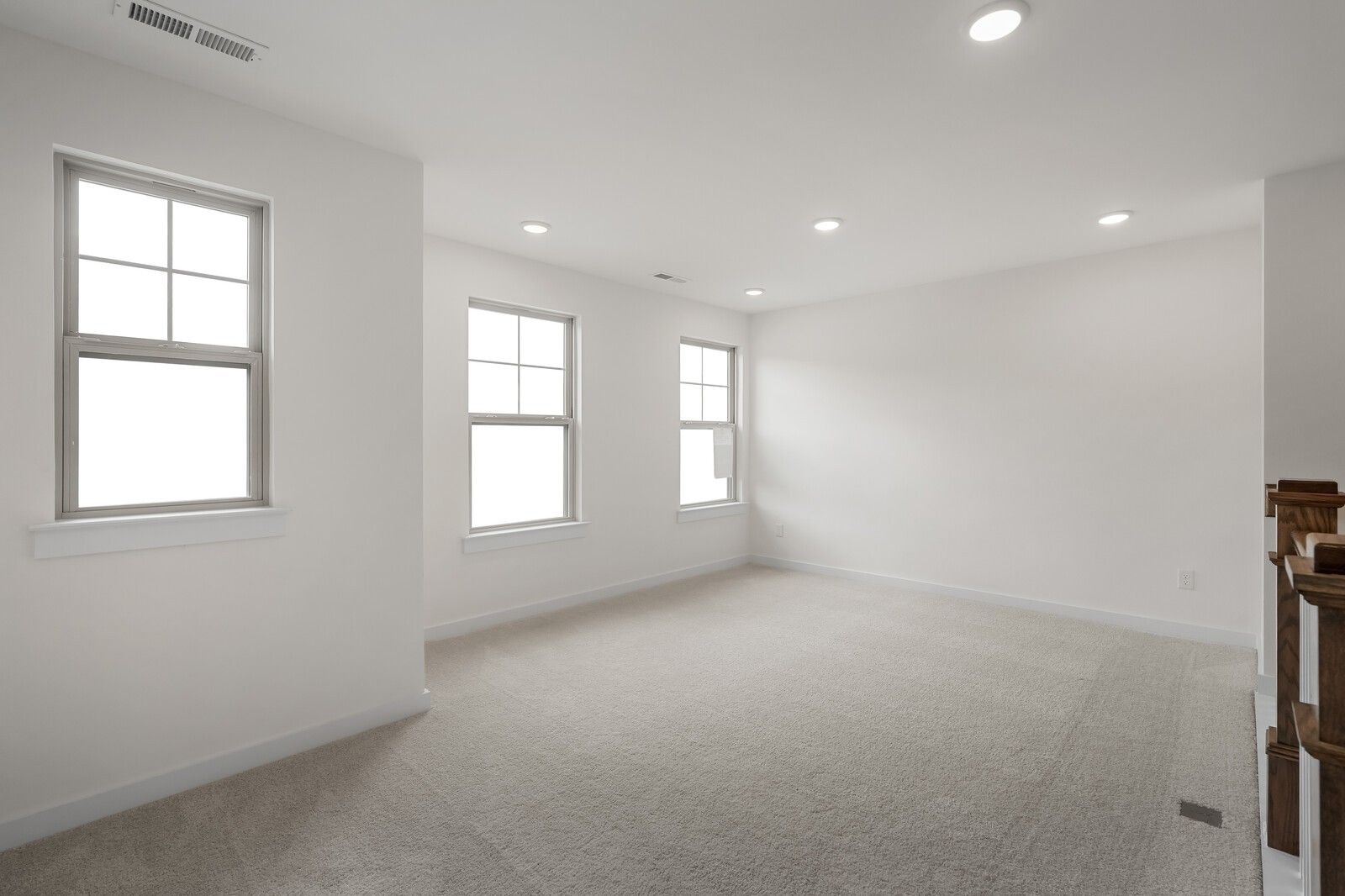 Bright upstairs loft with large windows, recessed lighting, beige carpet in Davidson Homes The Willow C, Gallatin, TN