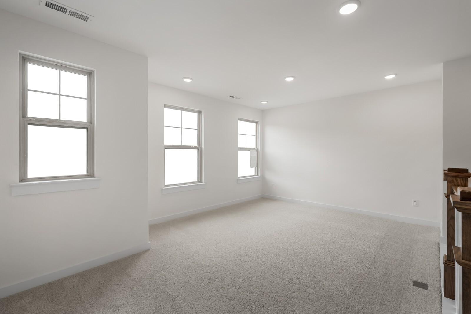 Bright upstairs loft with large windows, recessed lighting, beige carpet in Davidson Homes The Willow C, Gallatin, TN