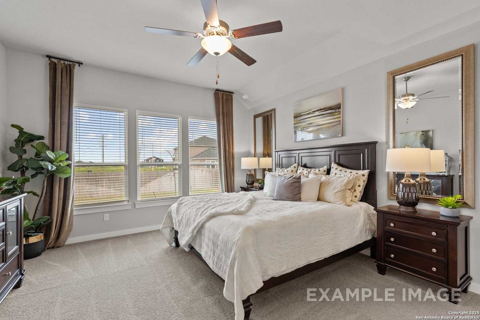 Elegant master bedroom with king bed, ceiling fan, large windows, and neutral decor in Davidson Homes The Collin B, Seguin, Texas