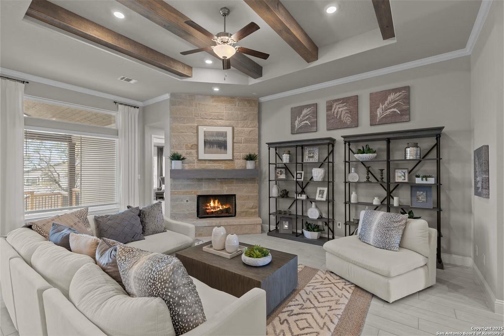 Cozy living room with stone fireplace, wooden beam ceiling, plush sectional sofa in Davidson Homes The Garner B, Castroville, Texas