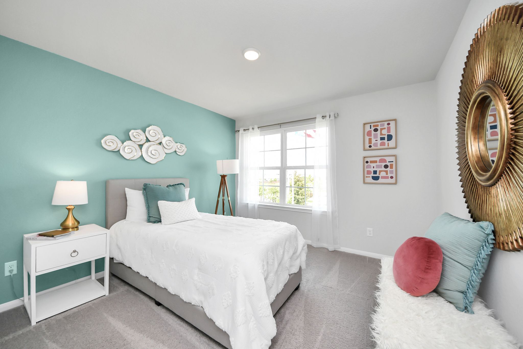 Modern bedroom in Sunterra, Katy, TX by Davidson Homes featuring a teal accent wall, queen bed, and decorative wall art.
