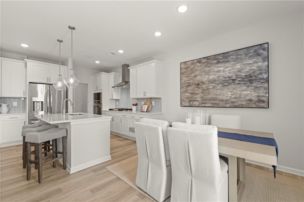 Modern kitchen with center island and dining area in The Wake B floor plan by Davidson Homes in Hemingway, Cumming, GA.