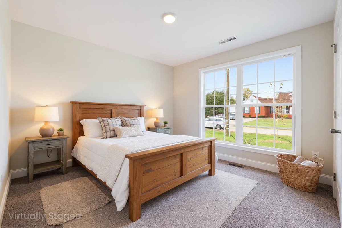 Staged bedroom at Chapel Hill in Athens Alabama with oak wood bed frame large window view and neutral decor