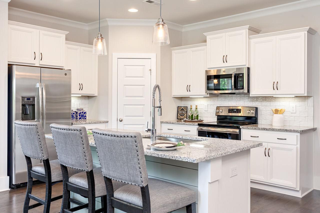 Spacious kitchen in Williams Pointe, Huntsville AL with white shaker cabinets, granite island, stainless steel appliances and bar seating